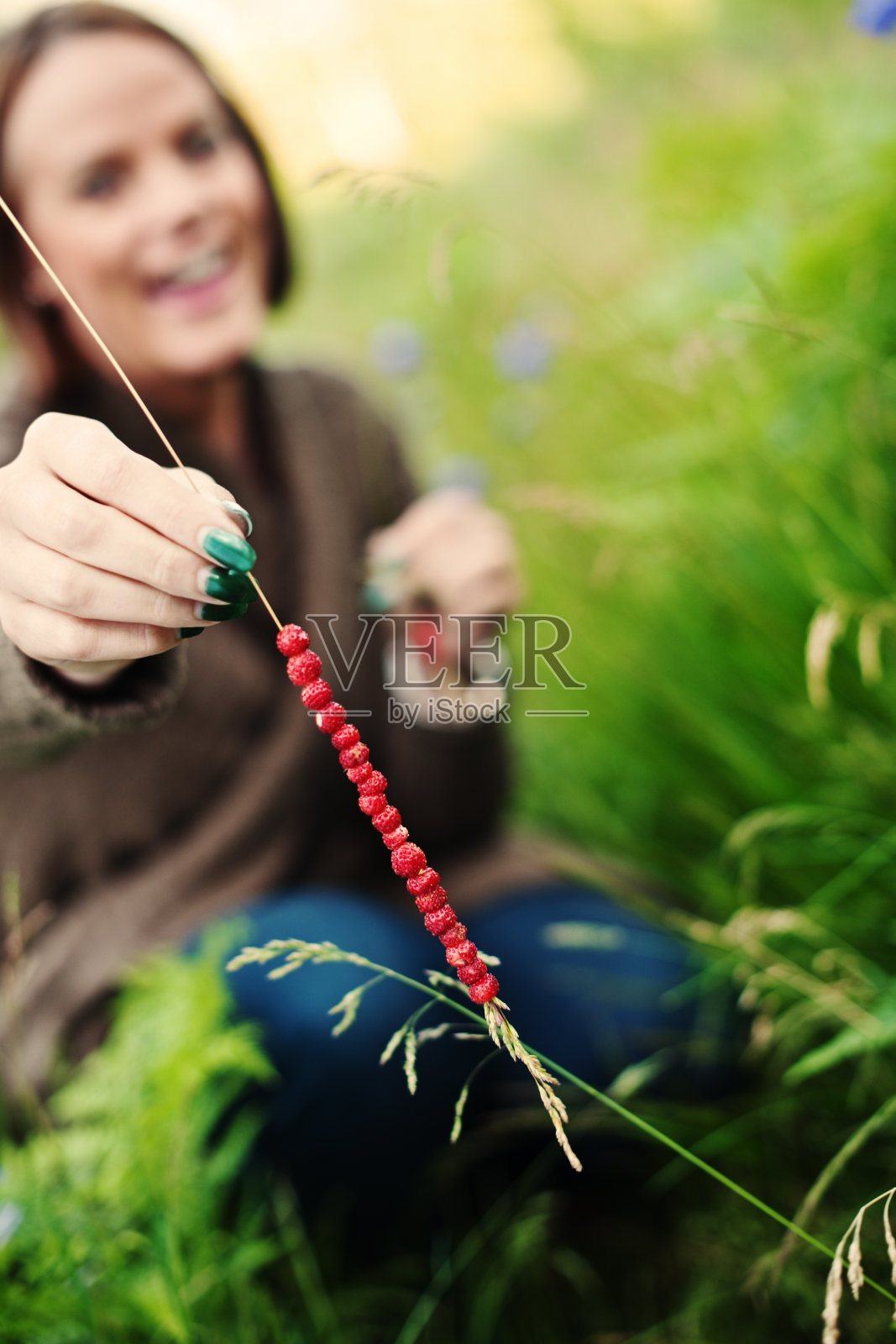 美丽的女人在户外抱着野草莓照片摄影图片