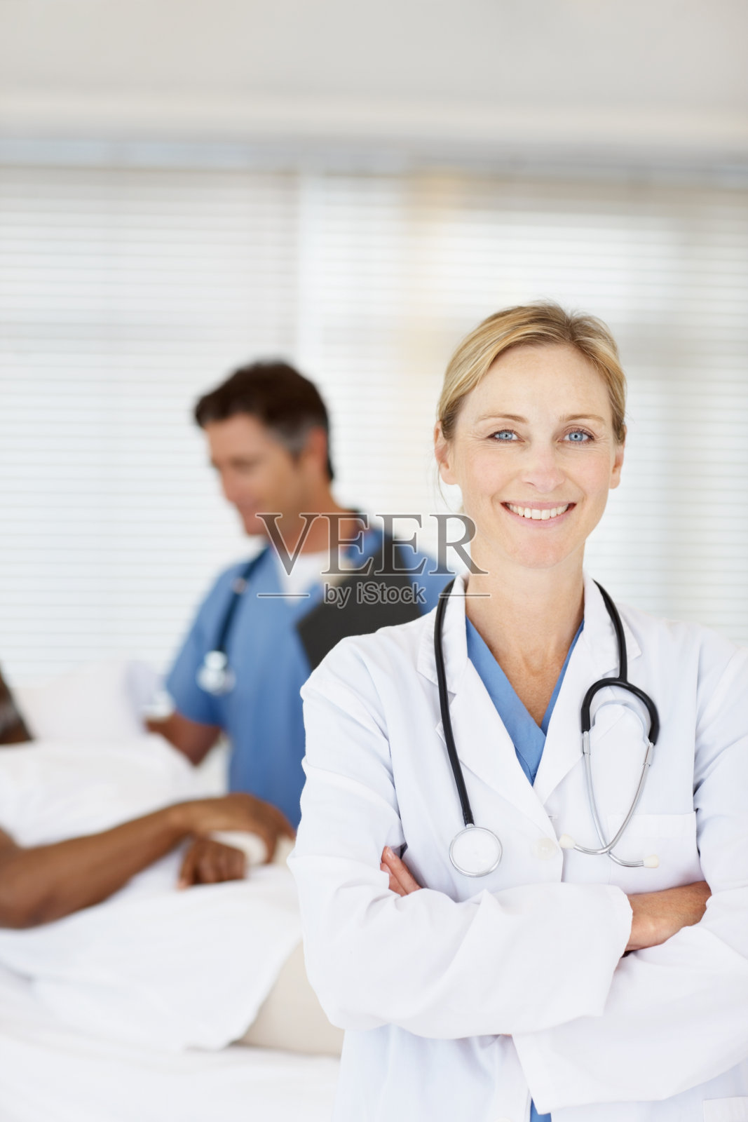 医生微笑着与同事在后台与病人交谈照片摄影图片