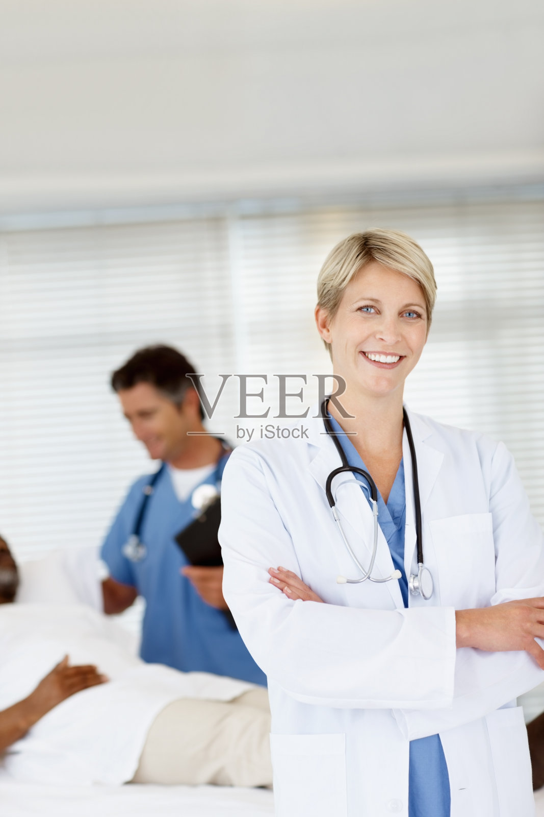 一个医生和她的同事在后台和一个病人谈话照片摄影图片