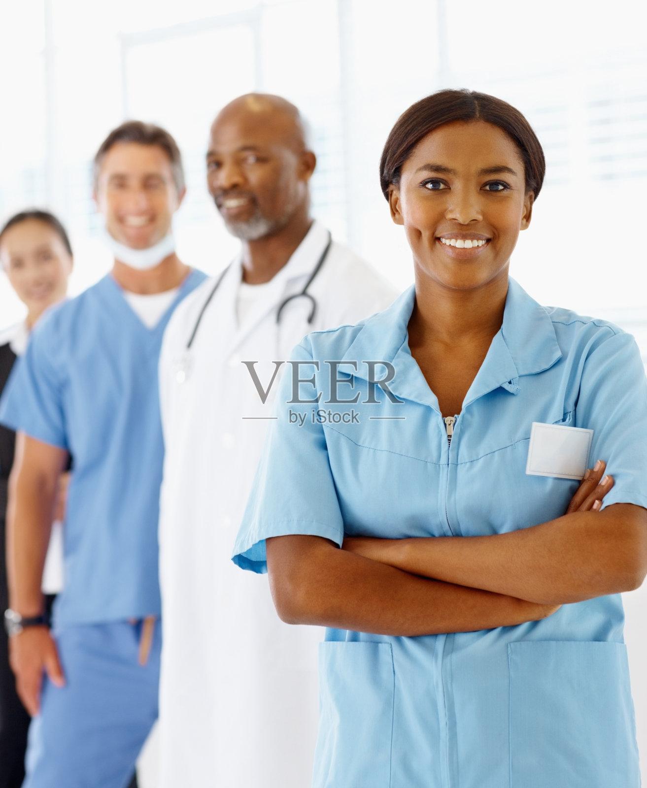 自信的护士和同事在后面照片摄影图片