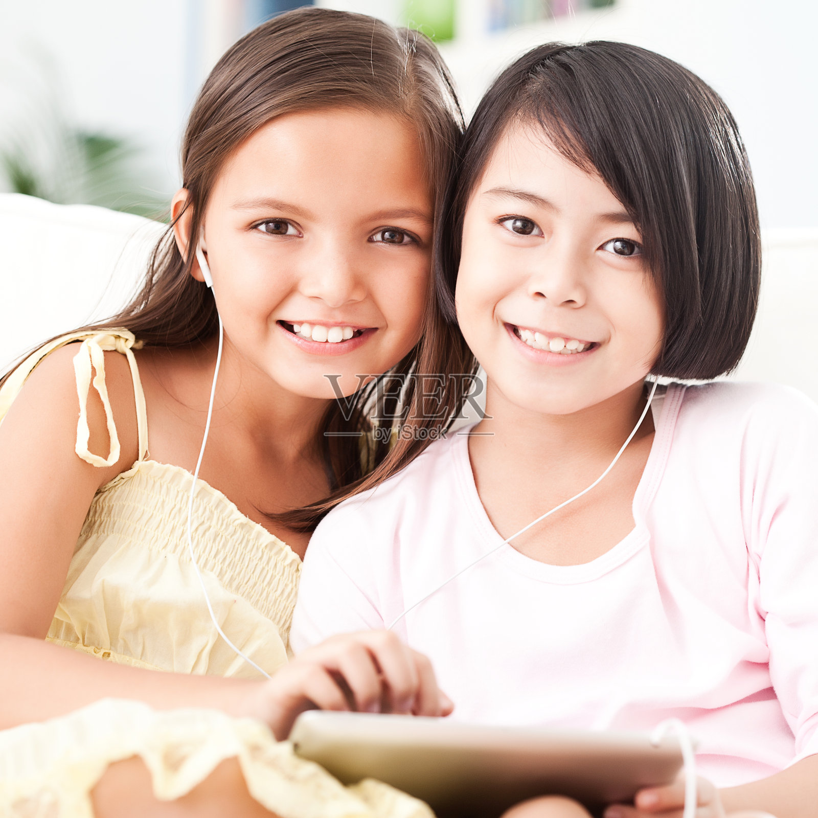 两个亚洲女孩在平板电脑上玩照片摄影图片