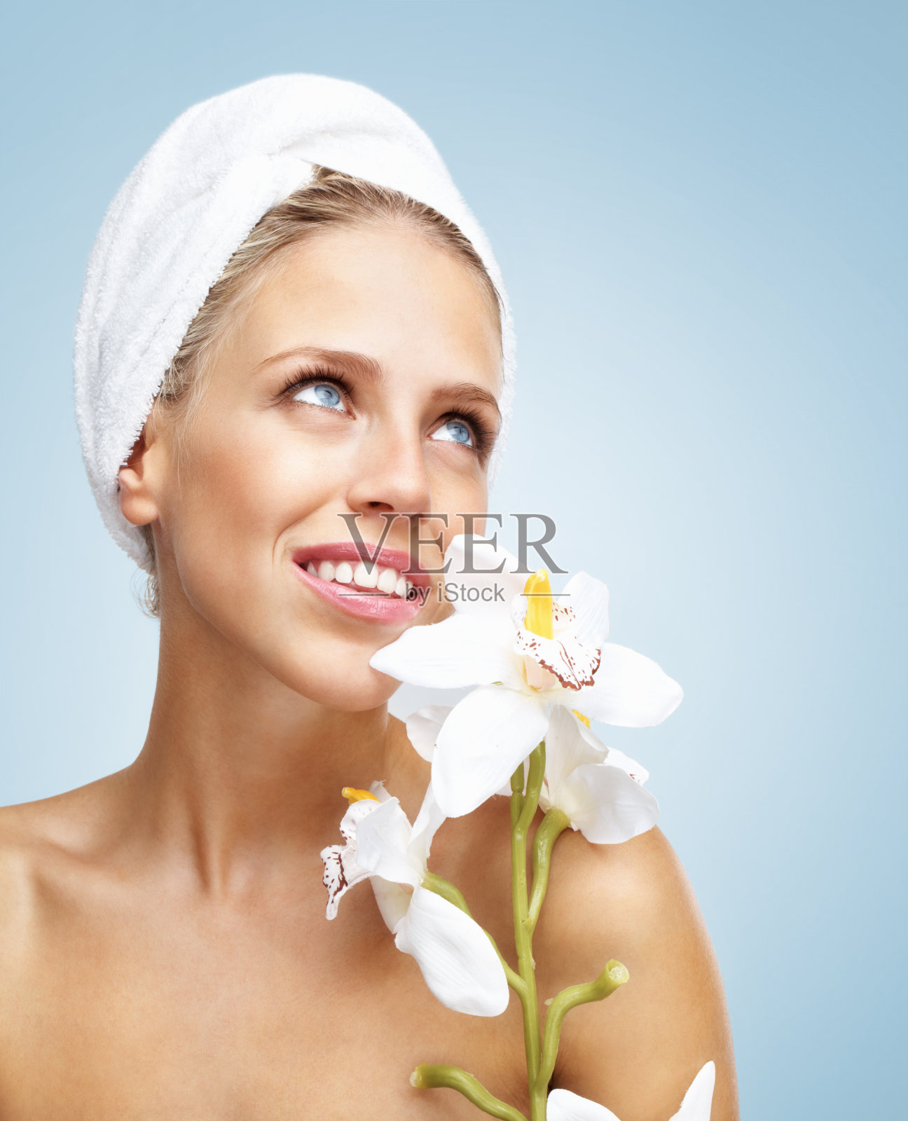 在蓝色背景下捧着鲜花的新鲜面孔的女人照片摄影图片