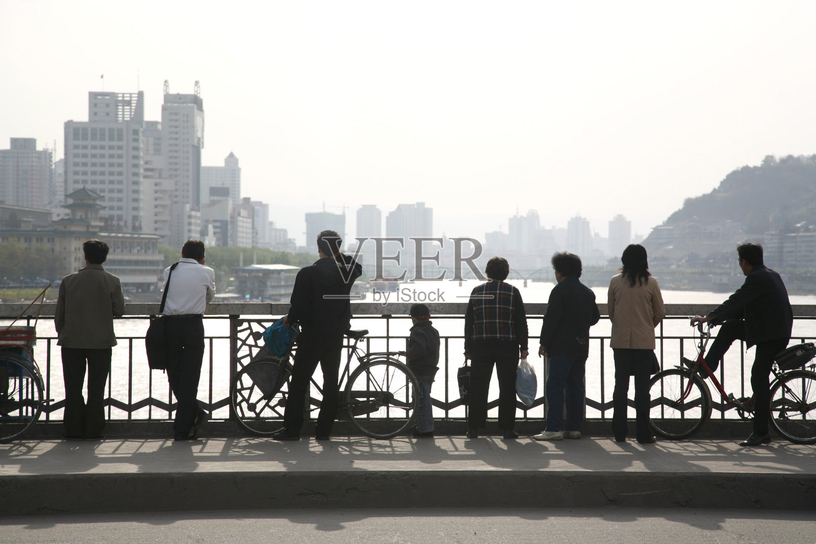 日落时分桥上人影的剪影照片摄影图片