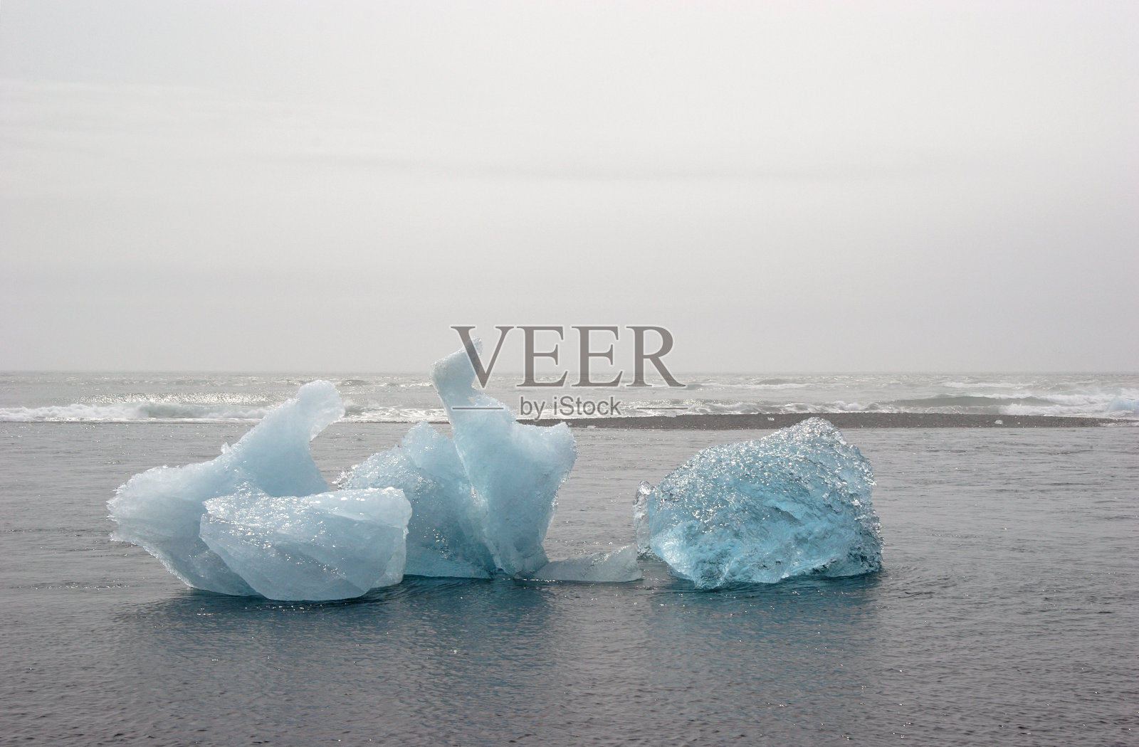 蓝色的冰山在海洋中融化照片摄影图片