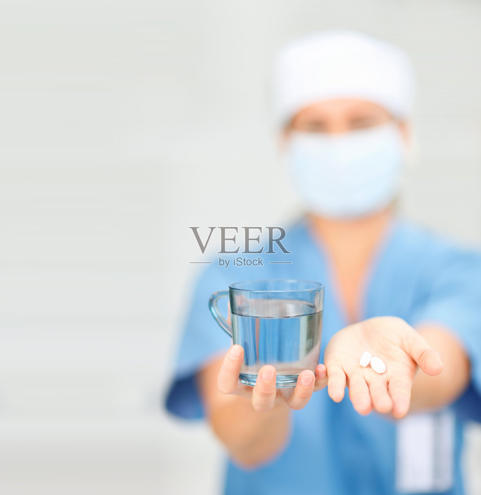 医生拿着一杯水和药丸照片摄影图片