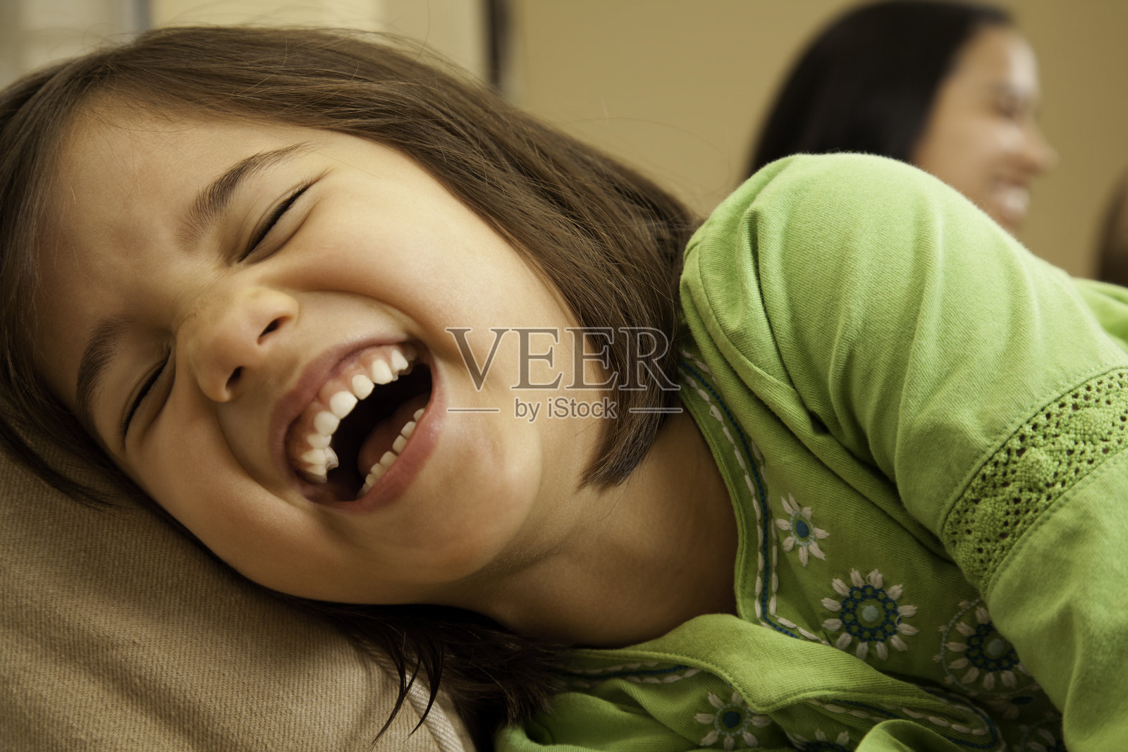 幼小的学前班女孩在家里歇斯底里地笑照片摄影图片