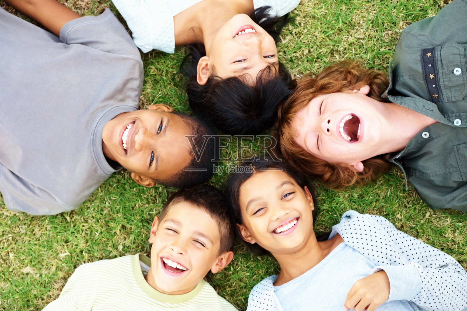 快乐的孩子们躺在草地上笑着照片摄影图片