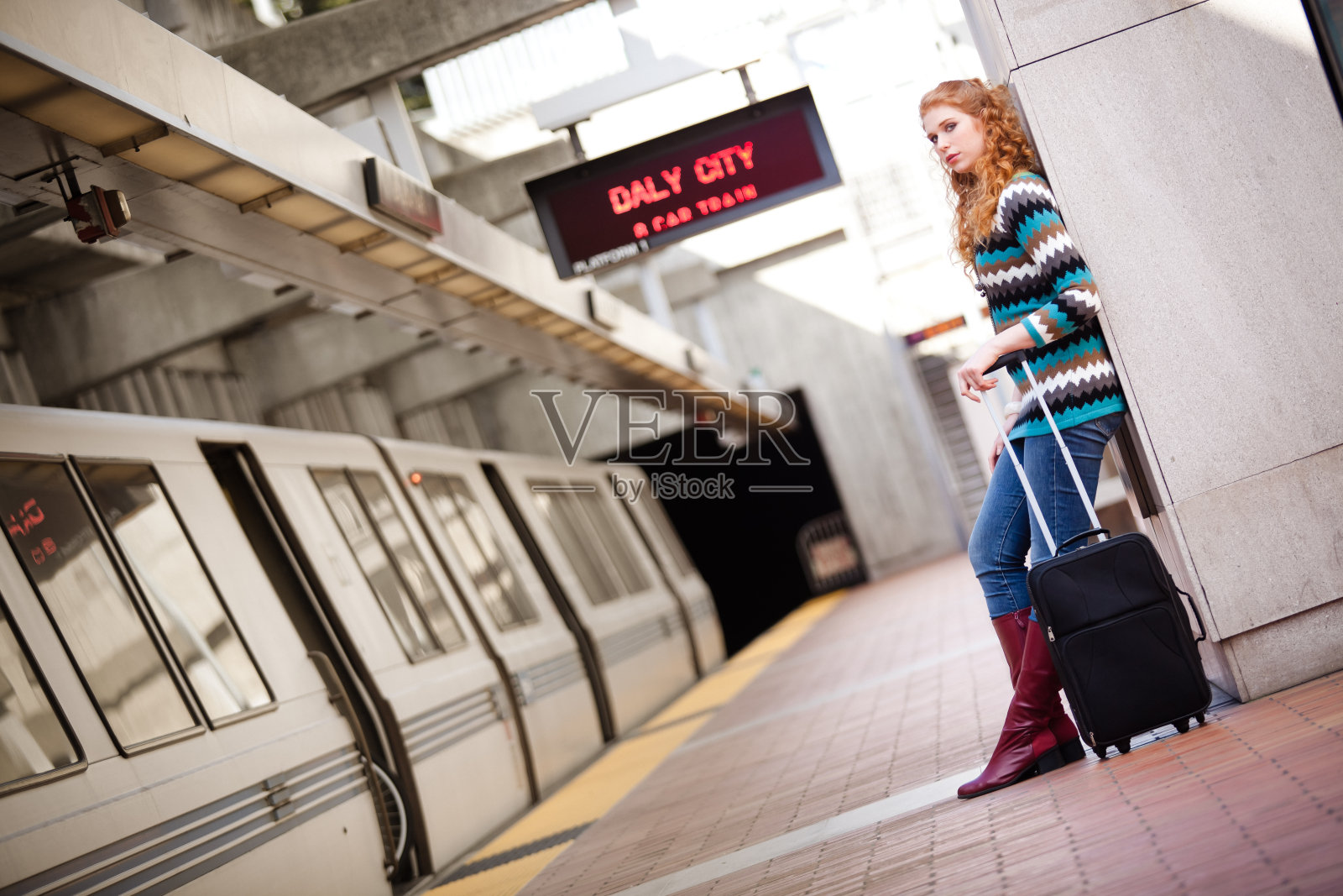 在BART车站，靠在墙上的女孩照片摄影图片