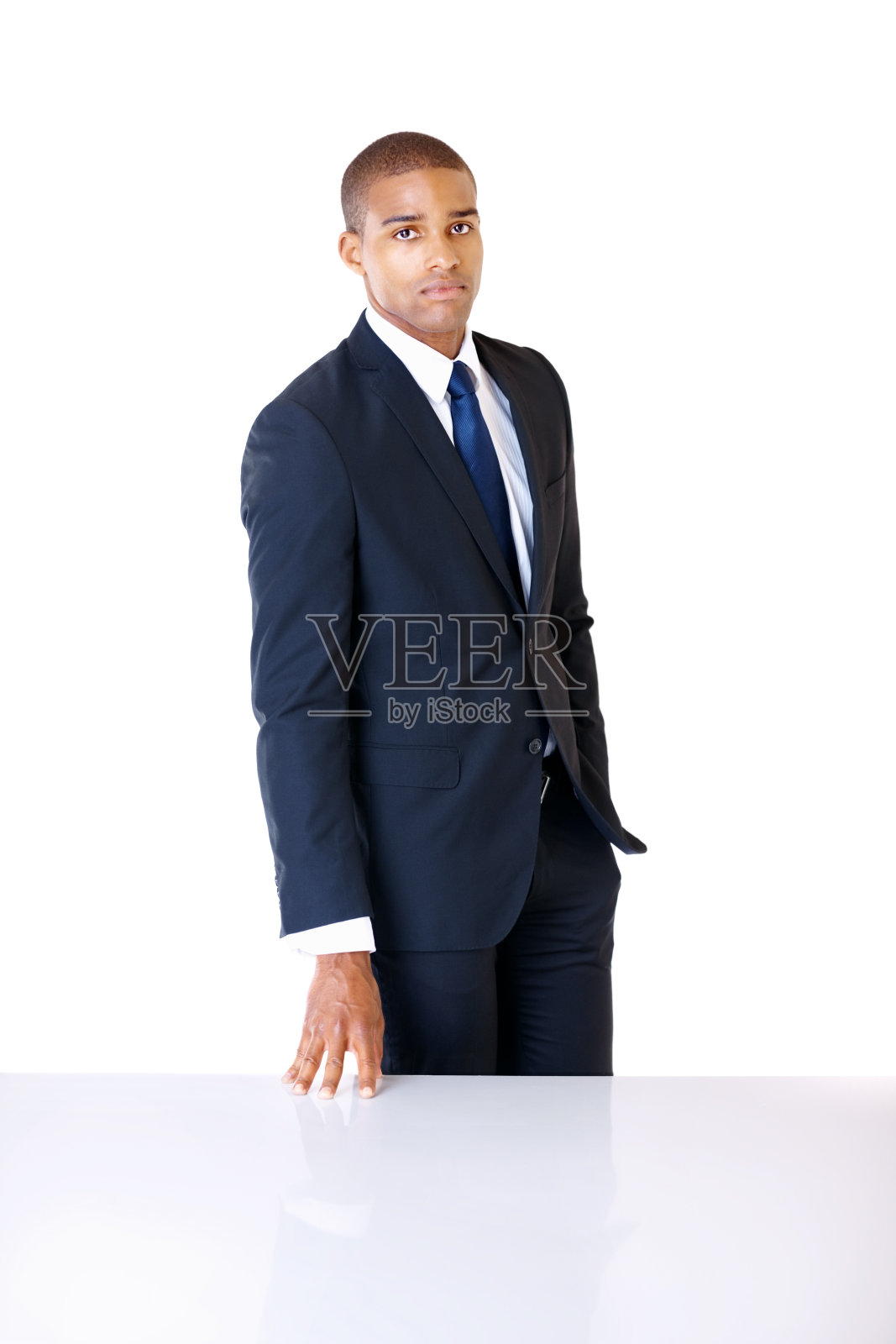 一个商人靠着白色的桌子站着照片摄影图片