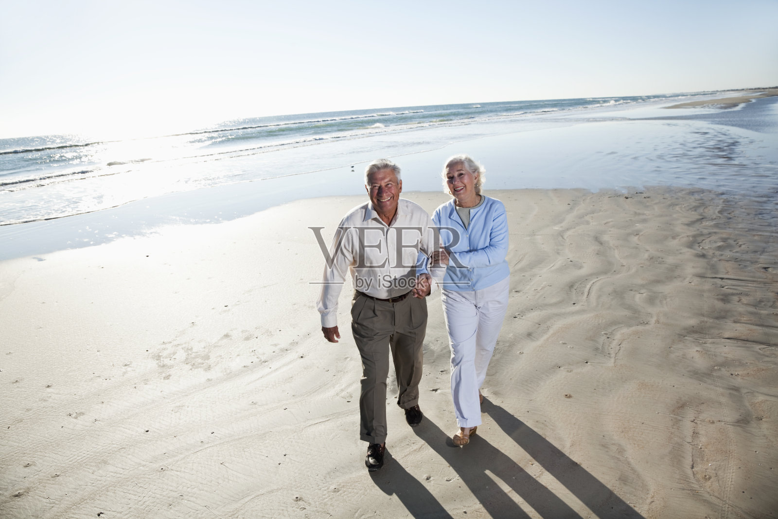 一对老年夫妇在海滩上散步照片摄影图片