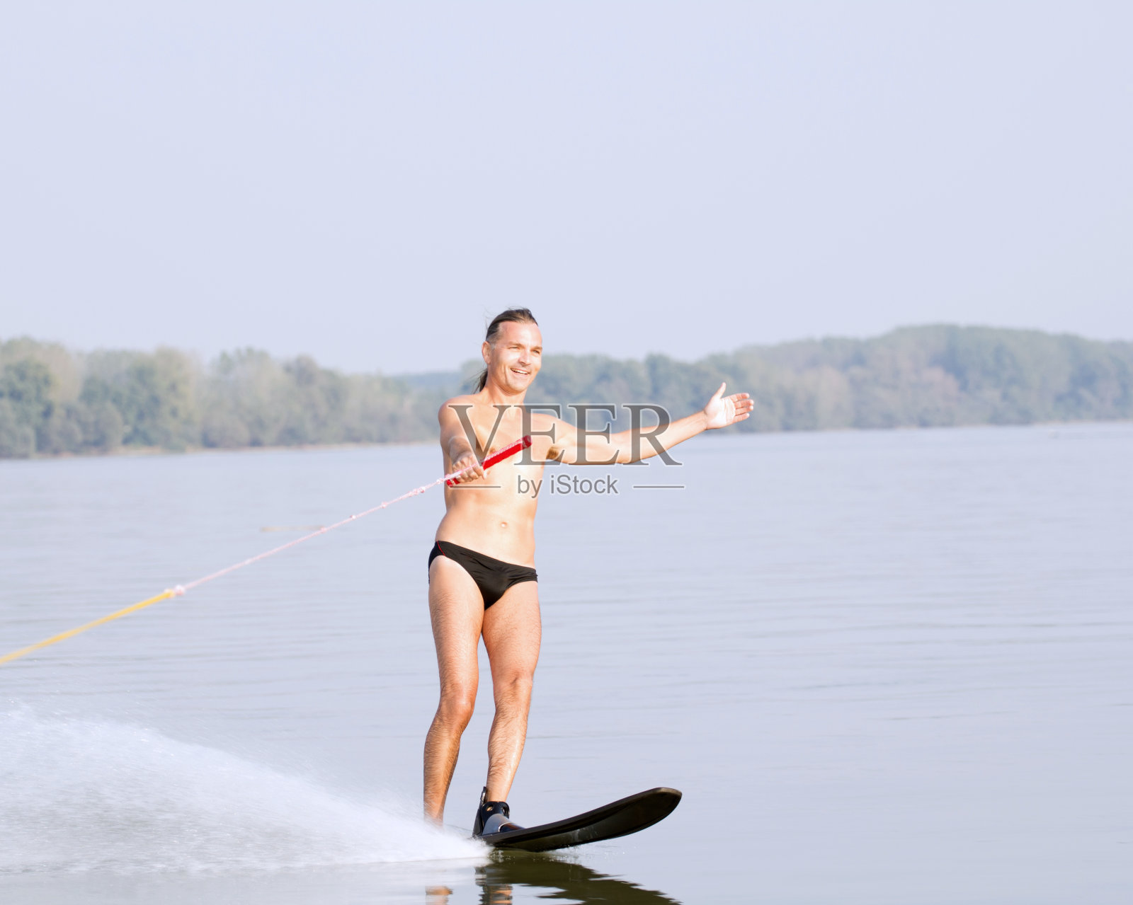 快乐的中年男子滑水。照片摄影图片