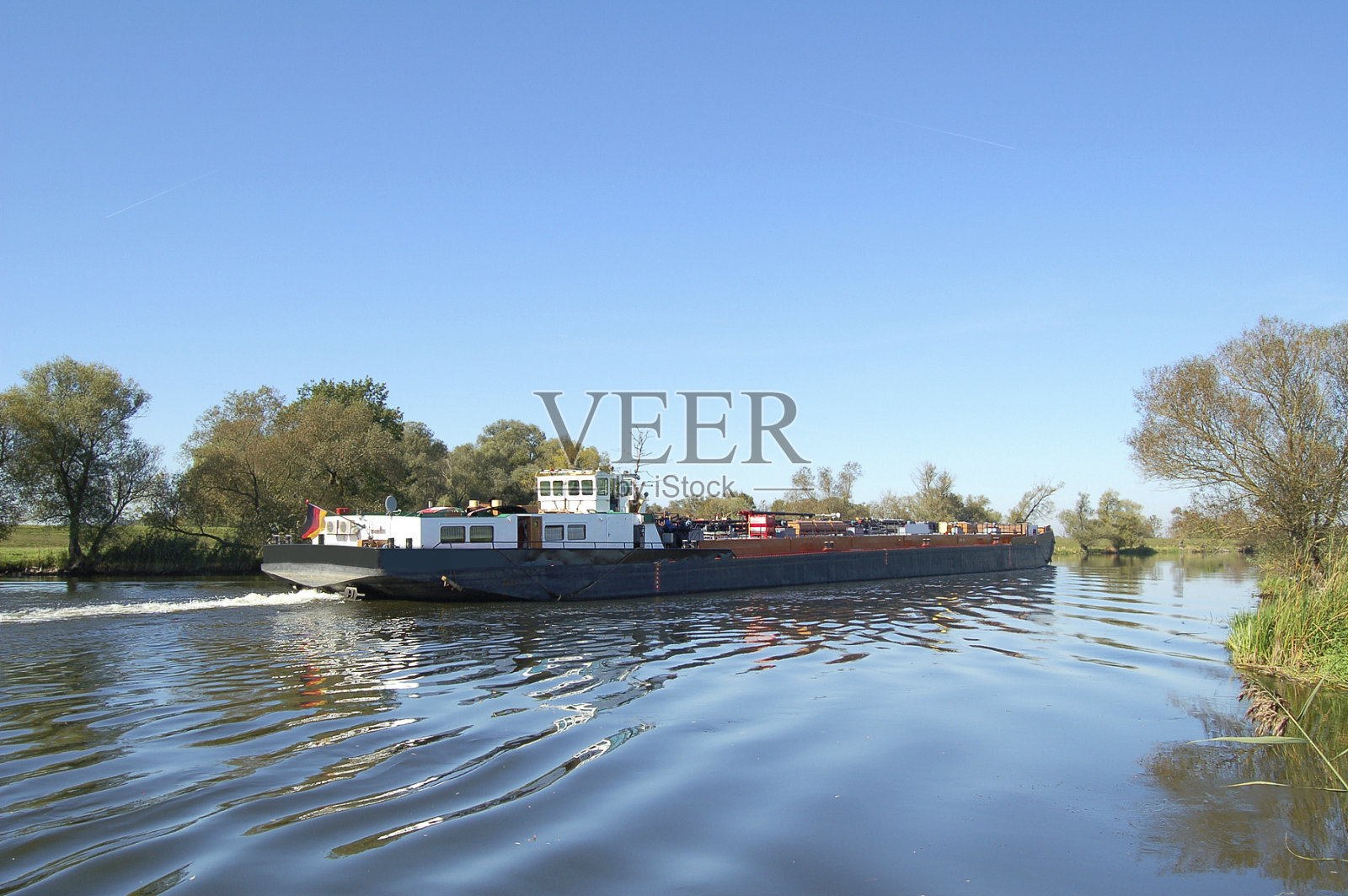 哈韦尔河(德国勃兰登堡)上挂着德国国旗的驳船照片摄影图片