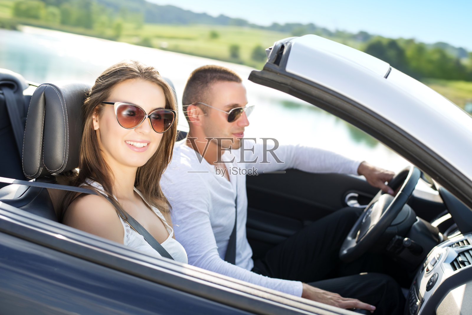 坐在敞篷车里的年轻夫妇照片摄影图片