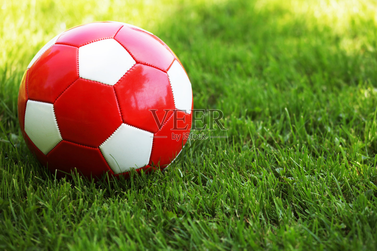 红色的足球在草地上照片摄影图片