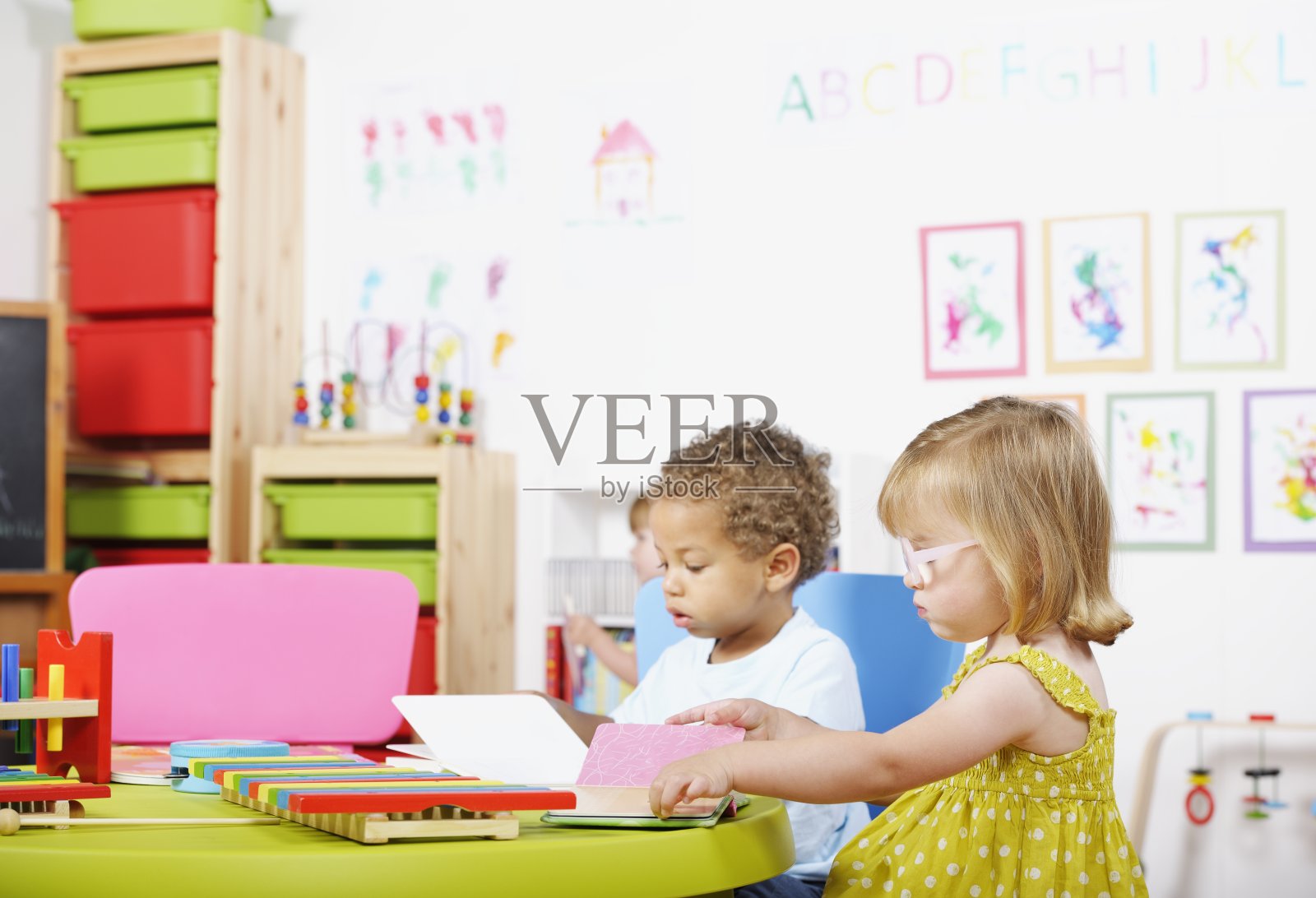 蹒跚学步的孩子在幼儿园里读书照片摄影图片