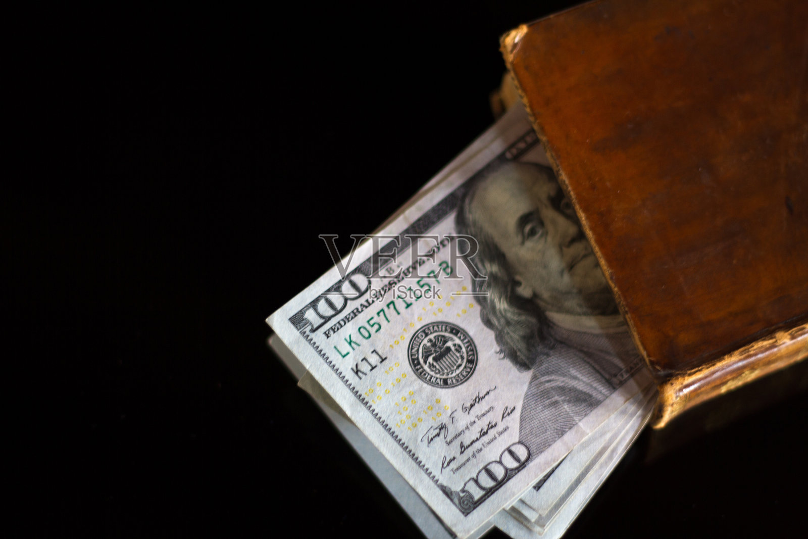 一叠新百元钞票在古董书上照片摄影图片