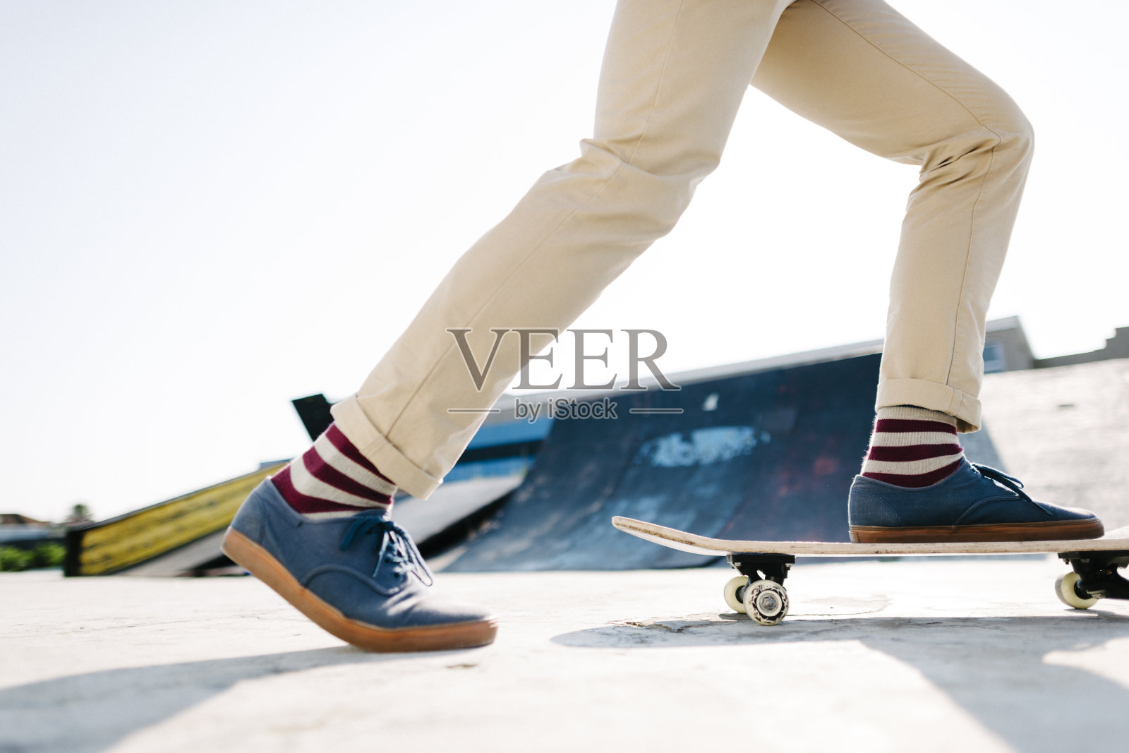 在一个滑板公园的滑板腿的低视野。照片摄影图片