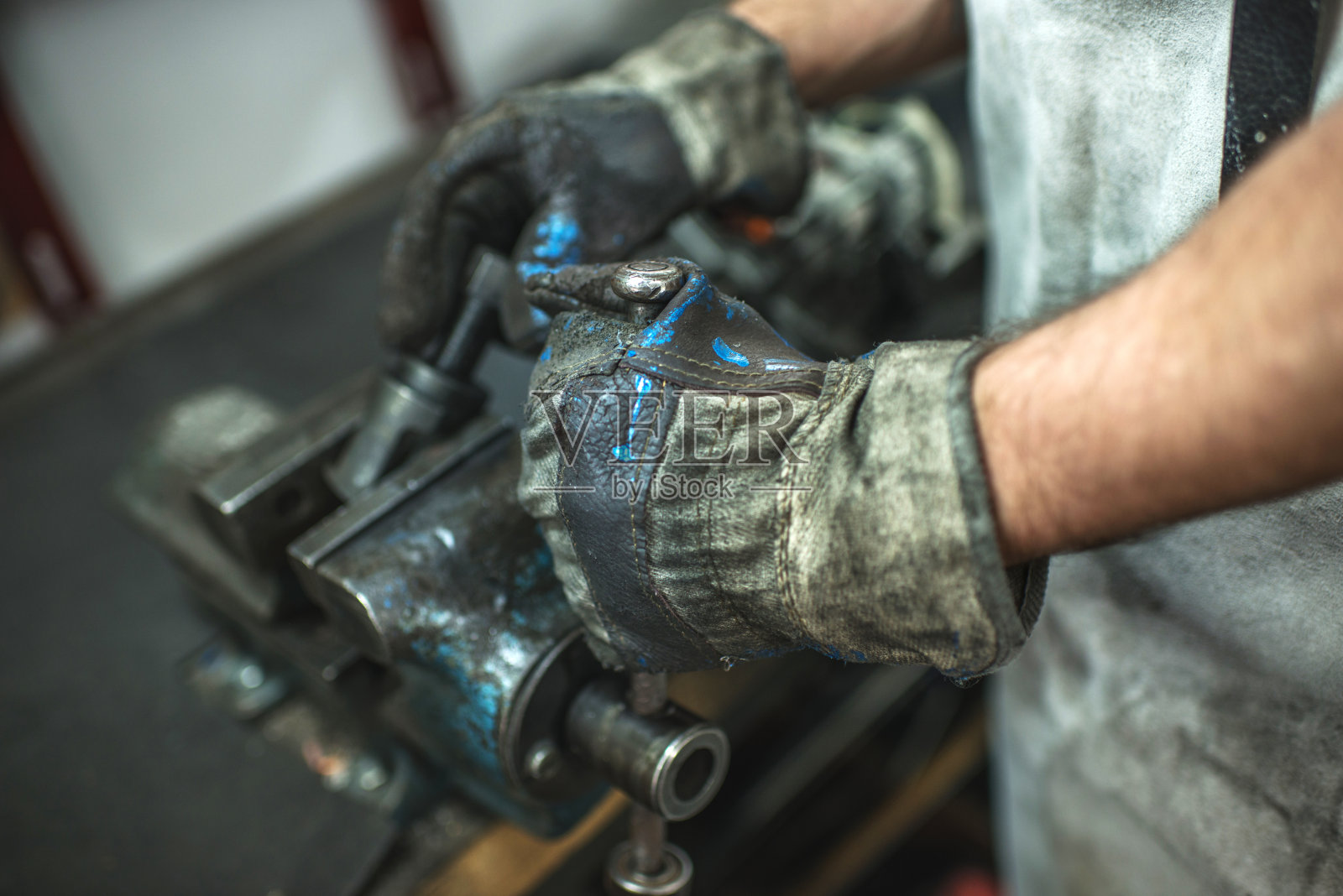 一个机械师在虎钳上工作的特写。照片摄影图片