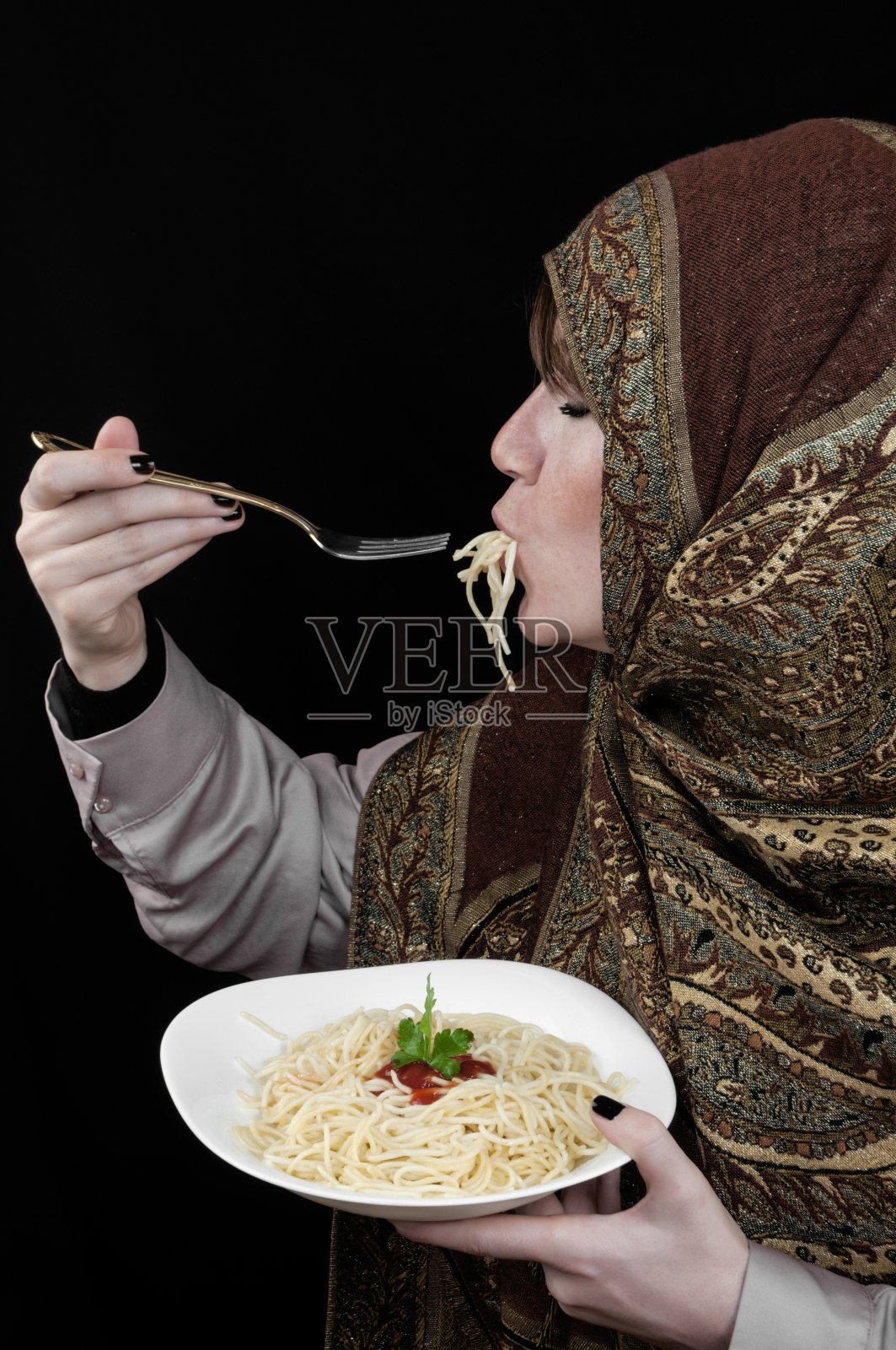 穆斯林女人在吃意大利面照片摄影图片