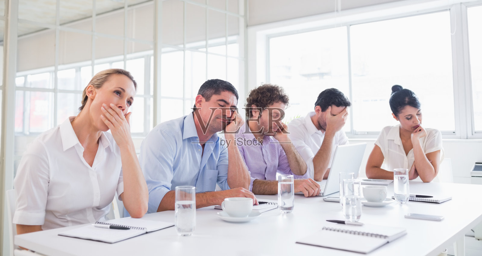 昏昏欲睡的高管们坐在会议桌旁照片摄影图片