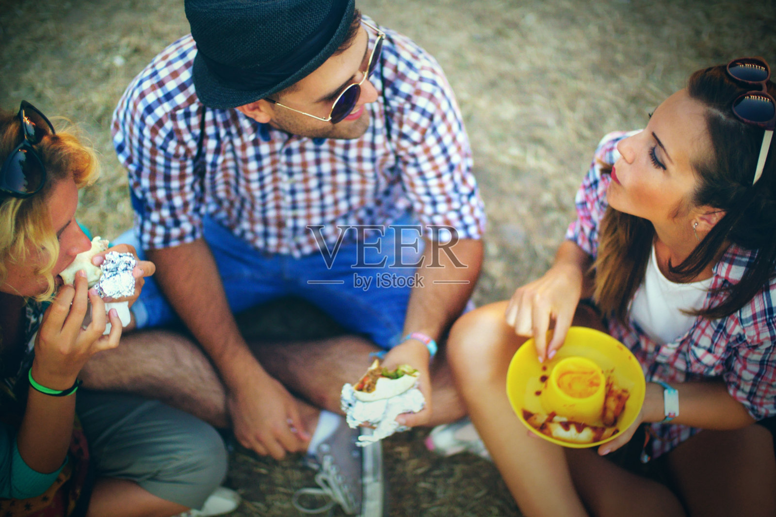 一群在户外吃饭的年轻人。照片摄影图片