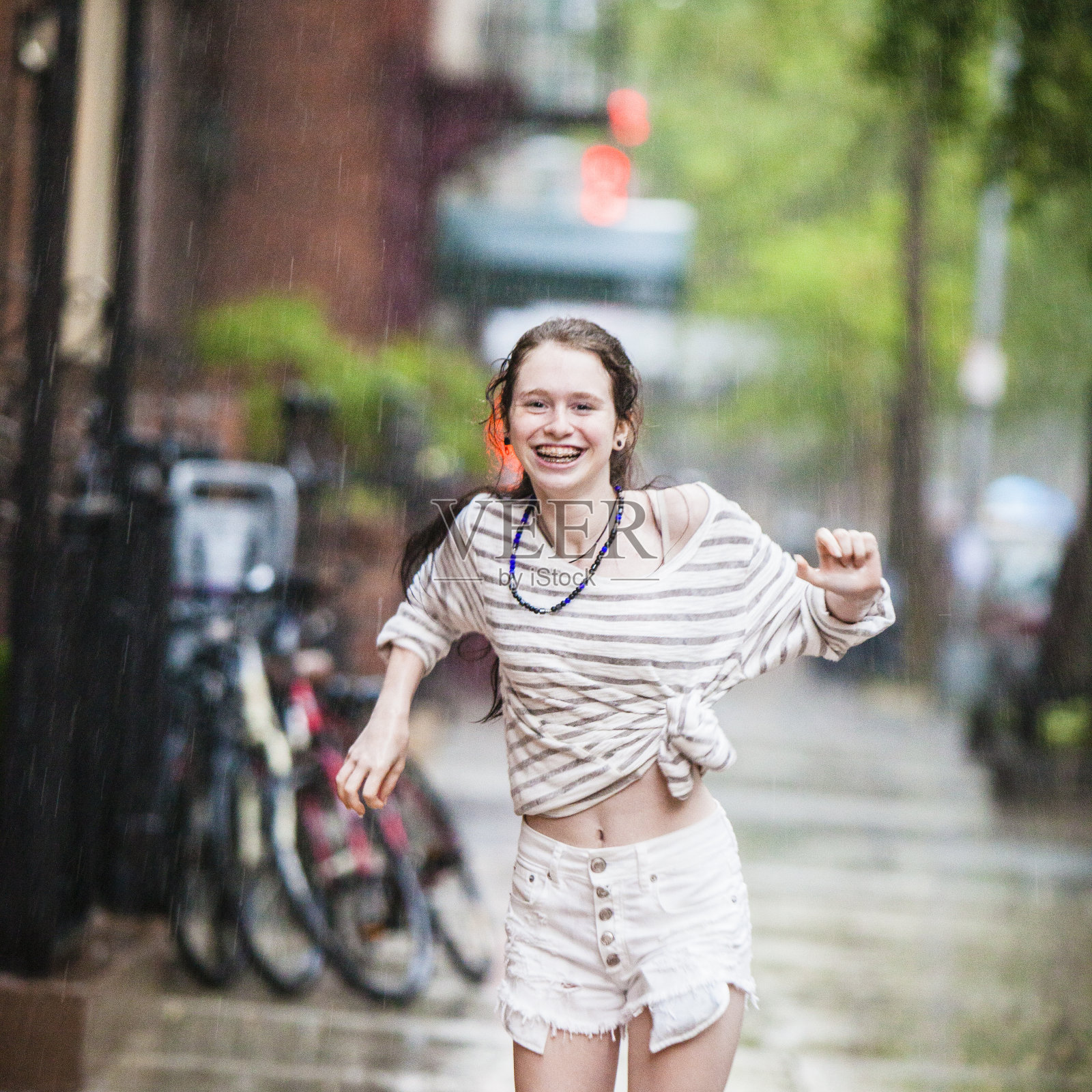 在夏雨中跳舞的少女照片摄影图片