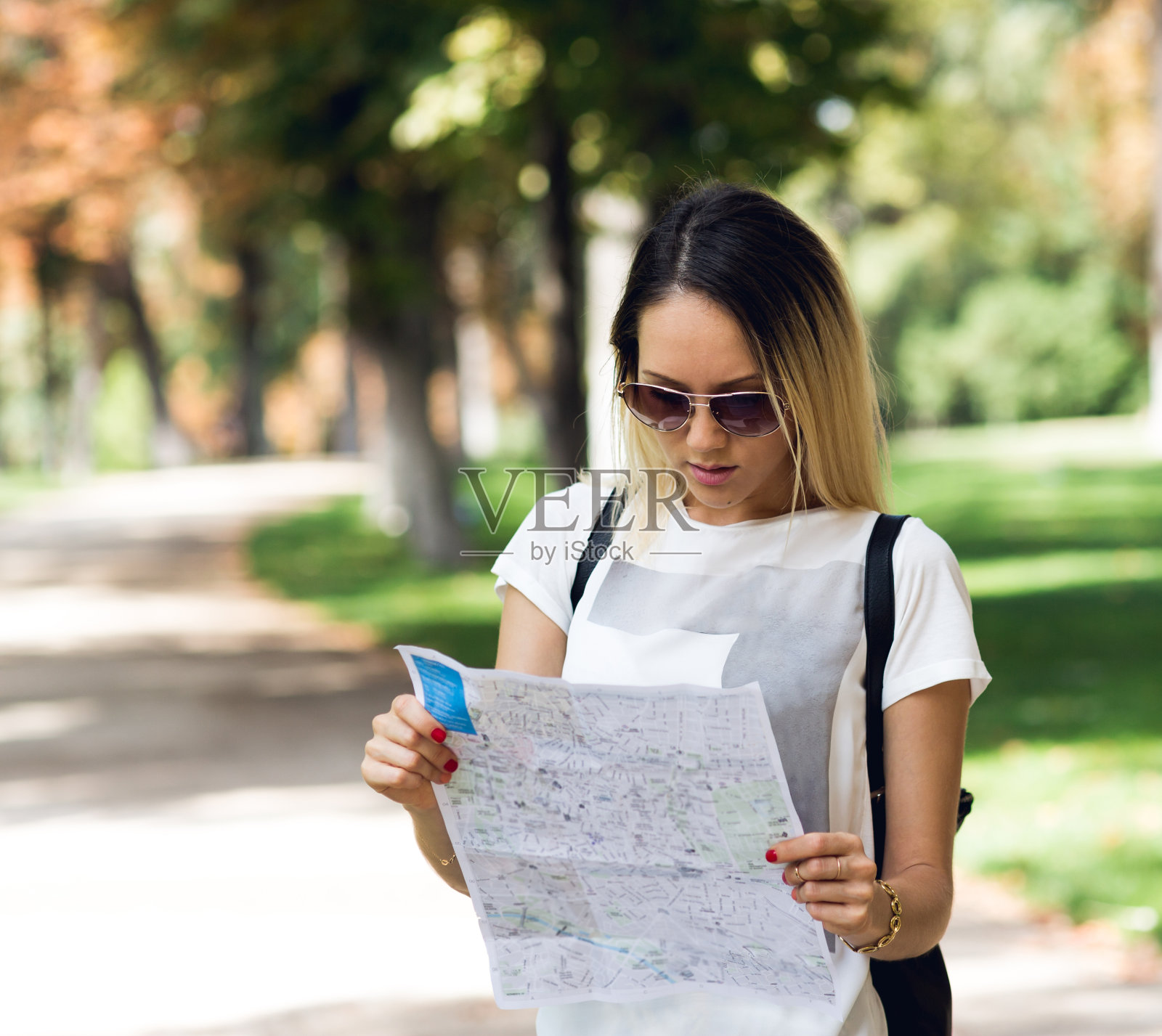 美丽的年轻女人在现实生活中使用地图照片摄影图片