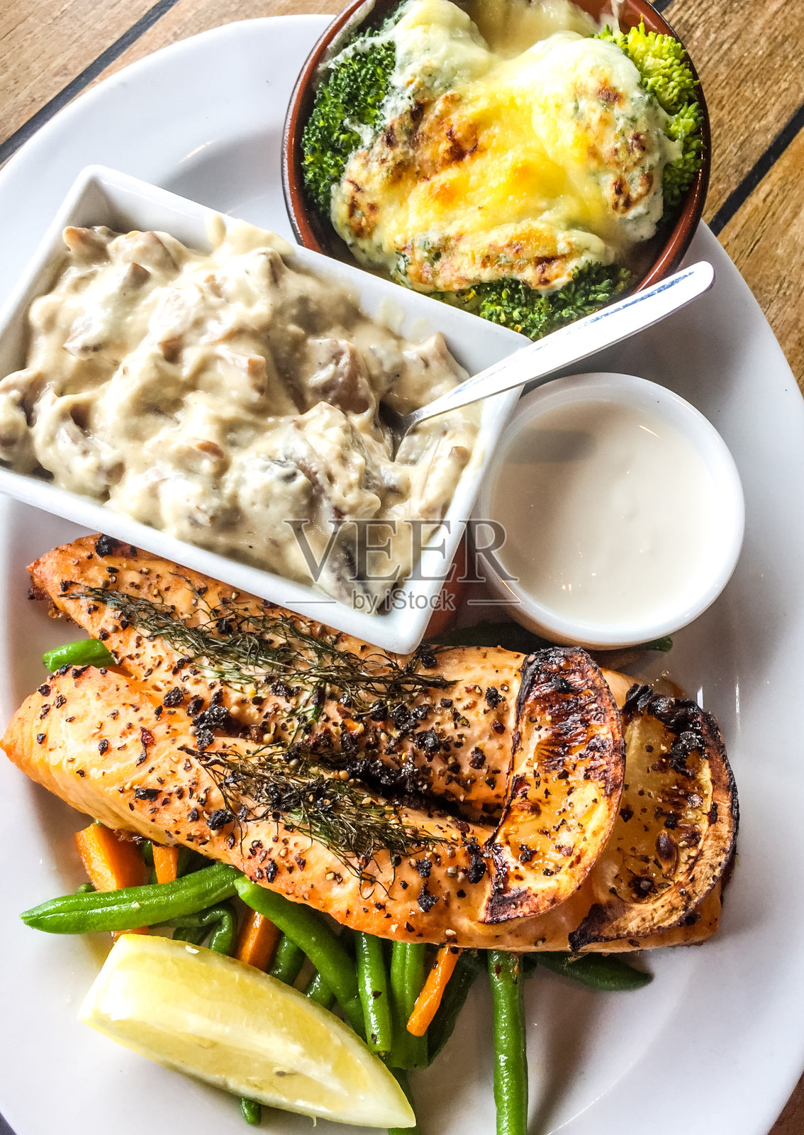 烤鲑鱼，蘑菇和蔬菜在盘子里照片摄影图片