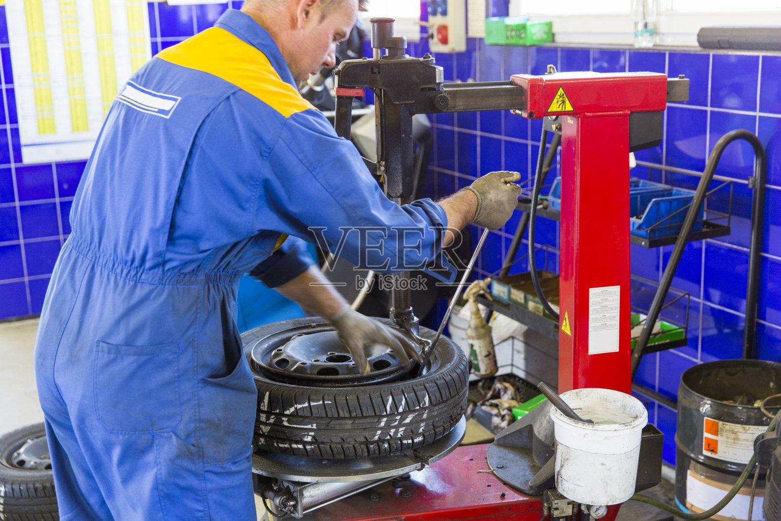 汽车修理工正在换轮胎。准备过冬的车照片摄影图片