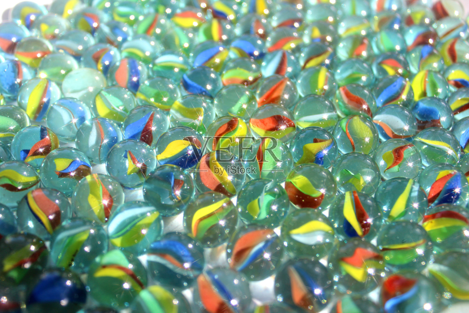 彩色玻璃弹子在阳光下闪闪发光，玩具游戏照片摄影图片