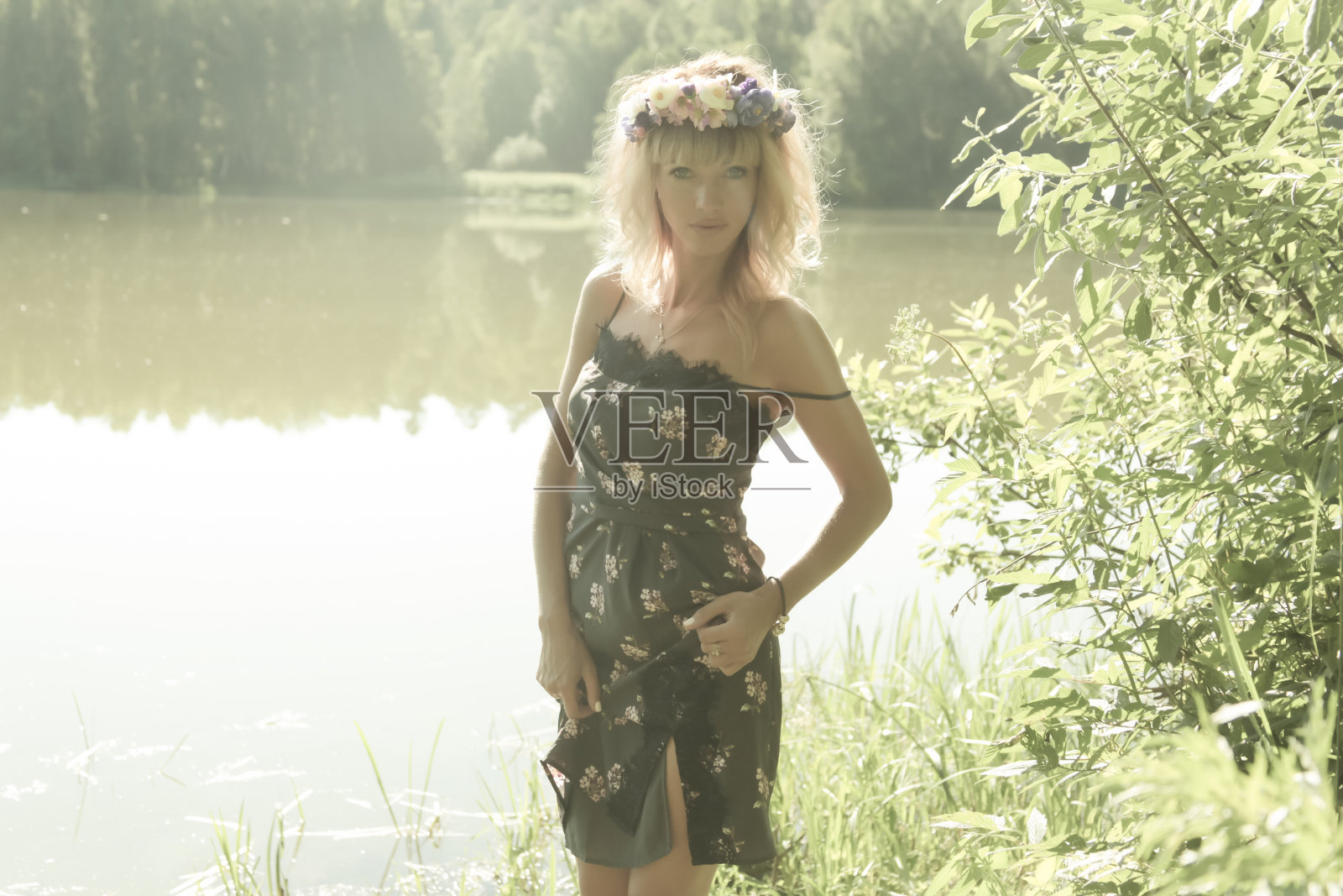 阳光明媚的一天。戴着花圈的女孩。照片摄影图片