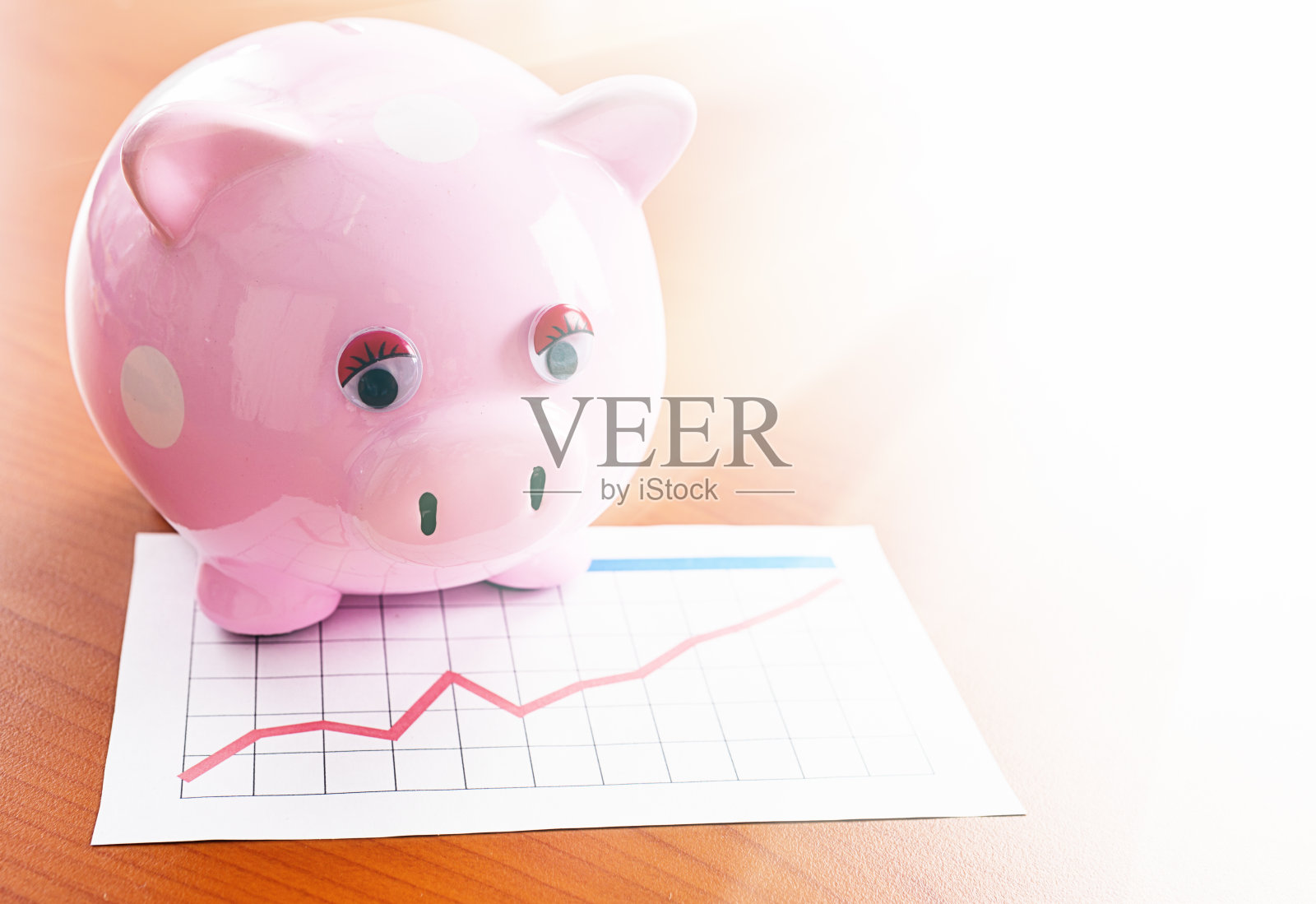 粉红色的存钱罐与上升的图形照片摄影图片