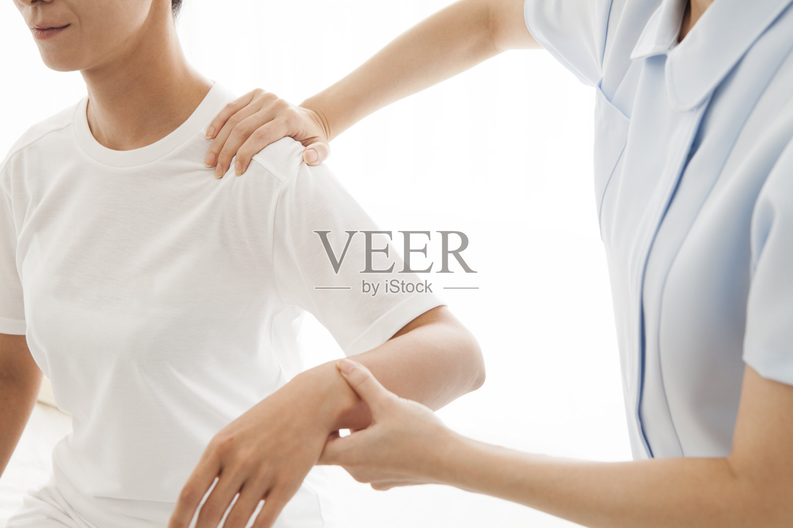 按摩师正在拉伸一位女士的手臂照片摄影图片