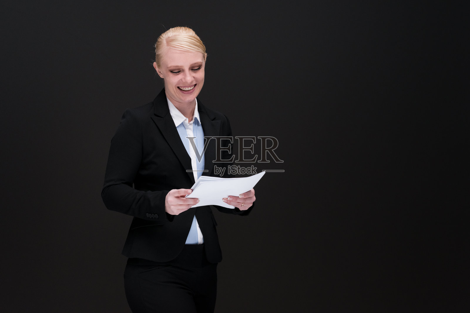 微笑着处理文件的女商人照片摄影图片