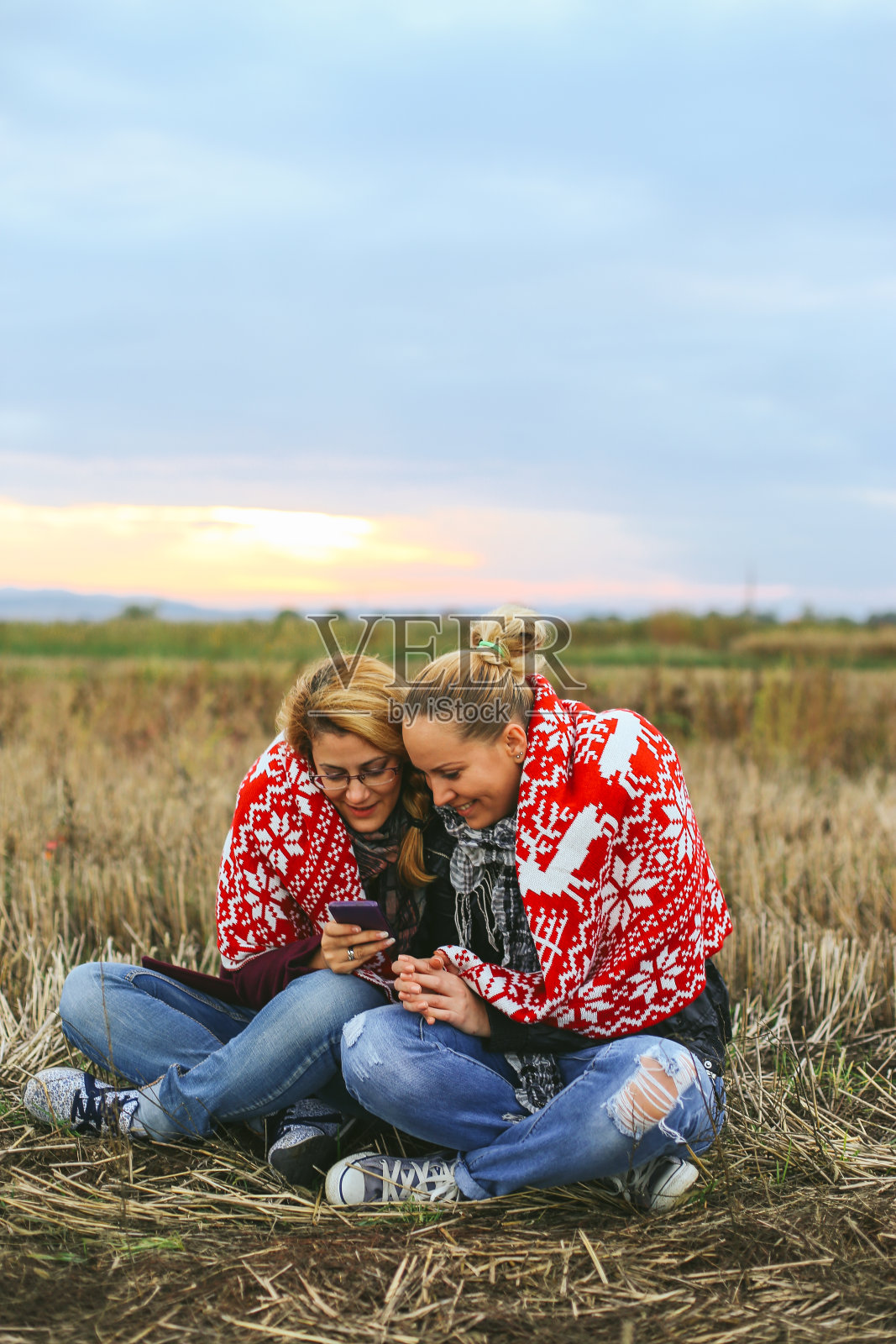 女孩在大自然中玩手机很开心照片摄影图片
