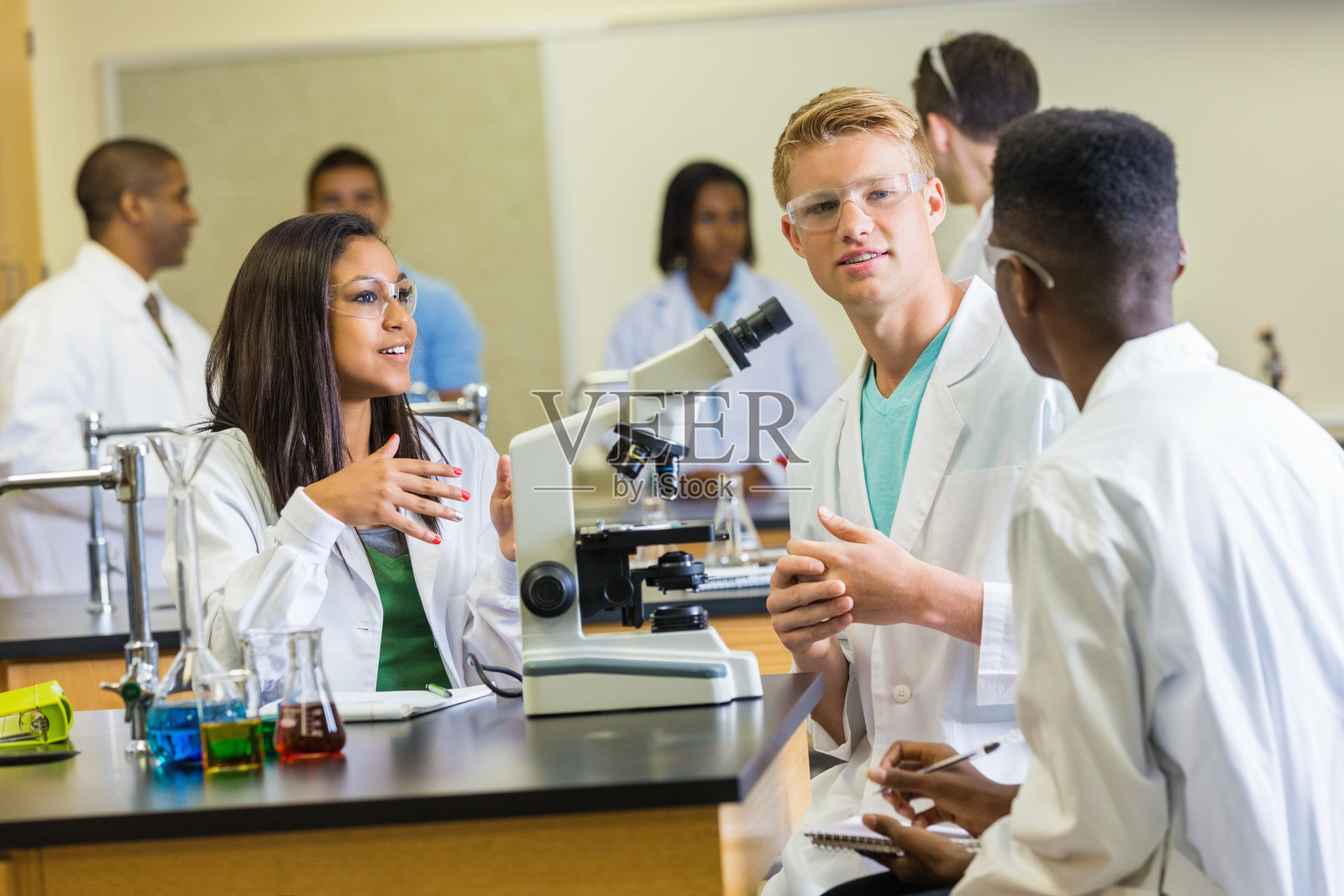 科学课的同学在用显微镜讨论作业照片摄影图片