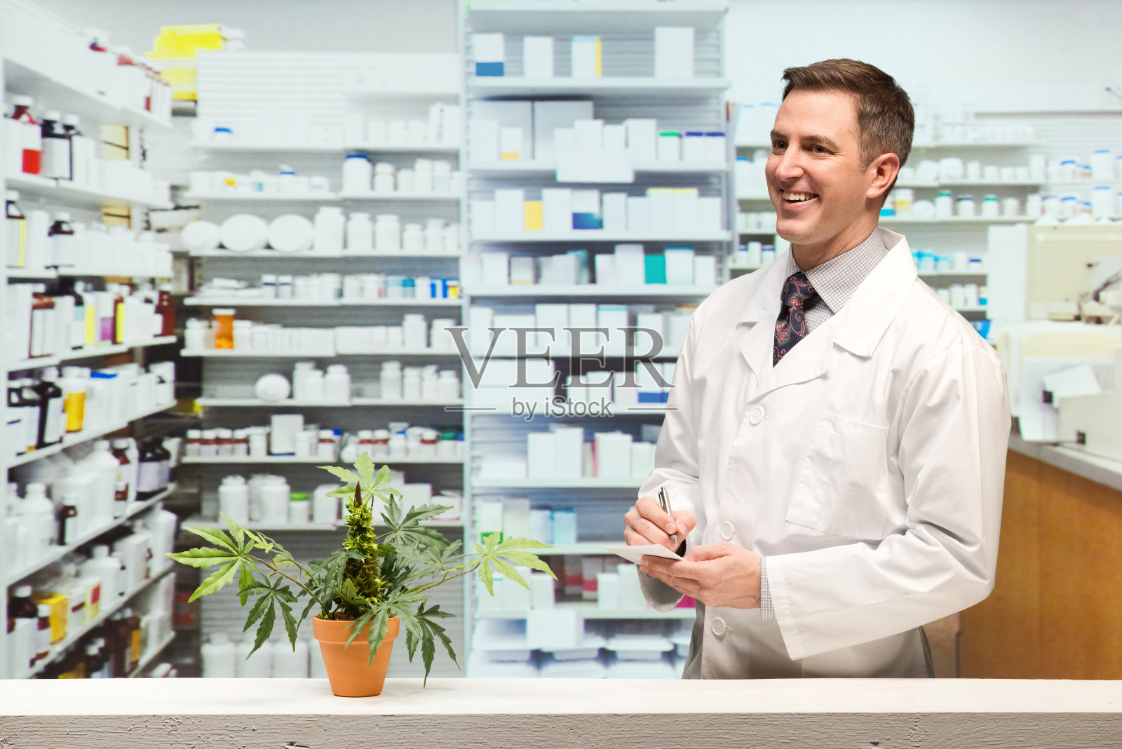 愉快的药剂师在药店和看别处照片摄影图片