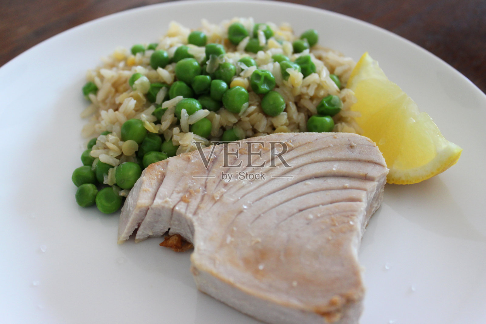 健康午餐，金枪鱼/金枪鱼牛排，糙米，豌豆，柠檬照片摄影图片