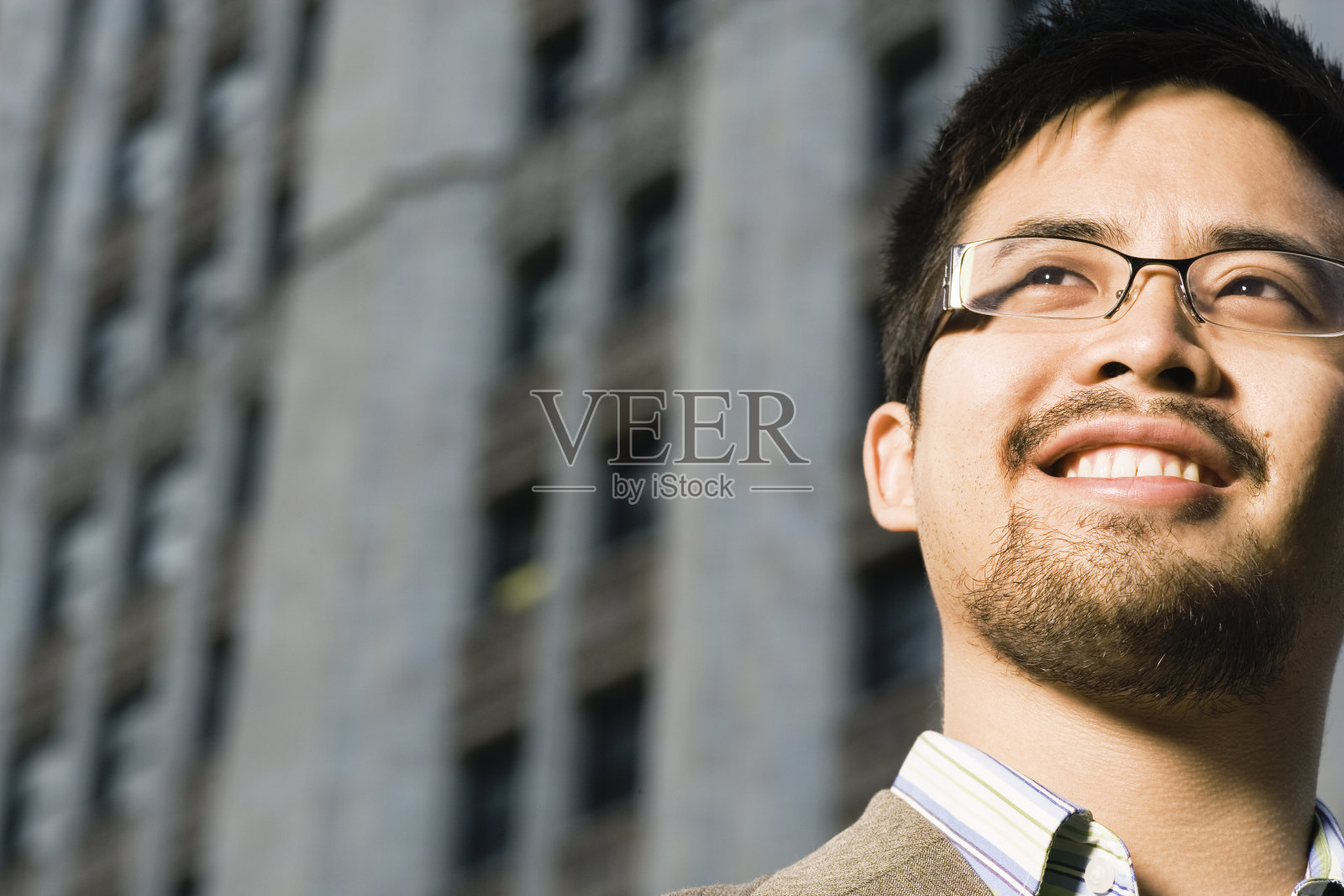 男人看向别处，微笑着照片摄影图片