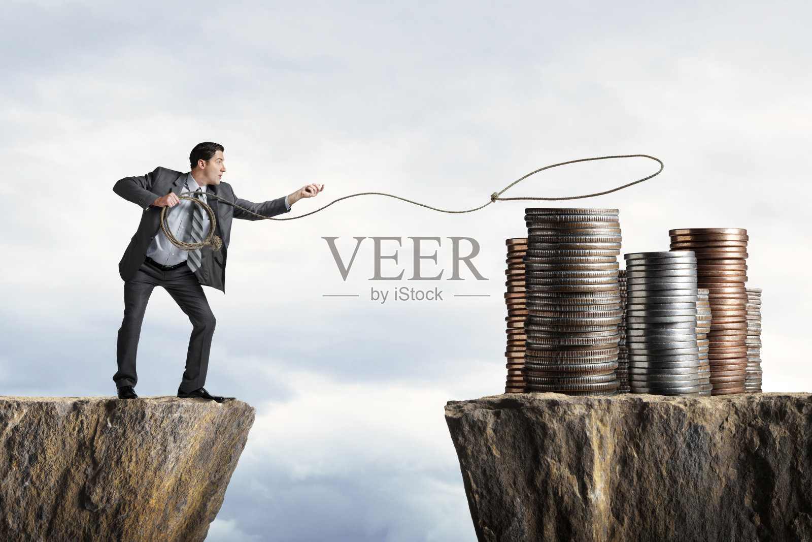 试图套索一堆硬币的商人照片摄影图片