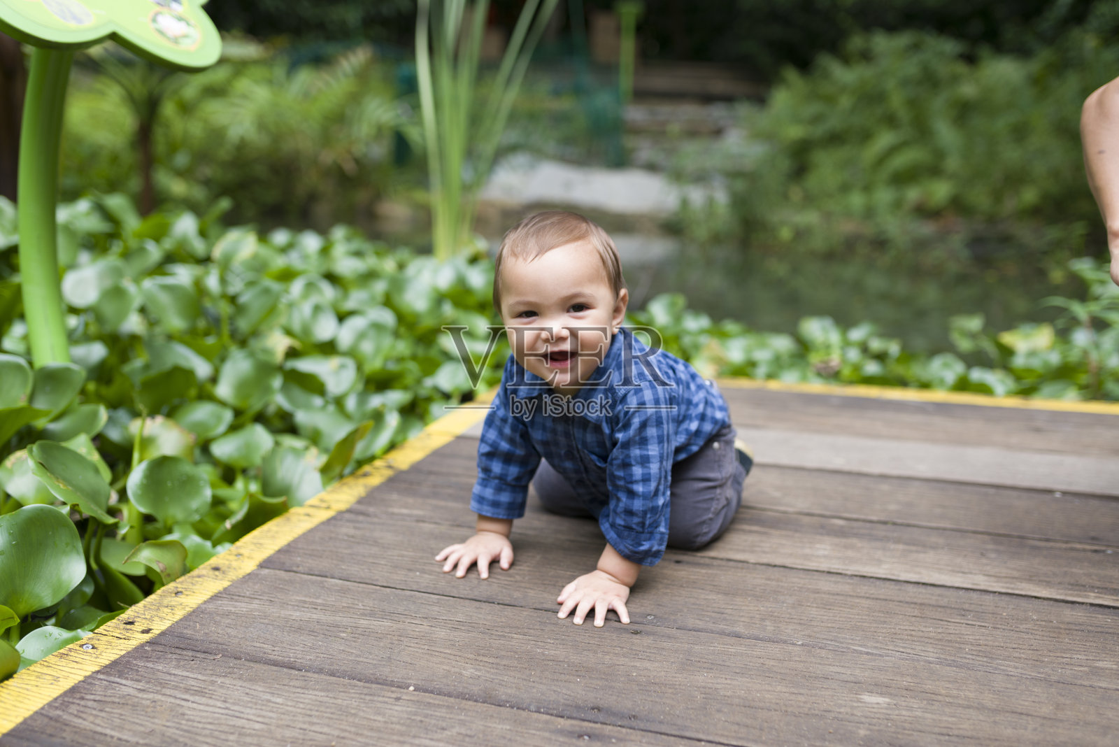 白种男婴和池塘。照片摄影图片