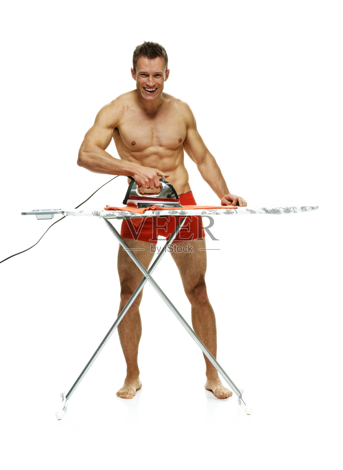 正在熨烫的快活的肌肉男照片摄影图片