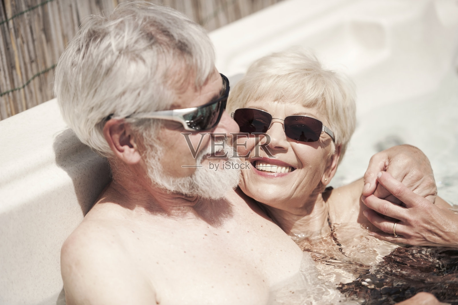 愉快的老夫妇在热水浴缸中享受夏日照片摄影图片