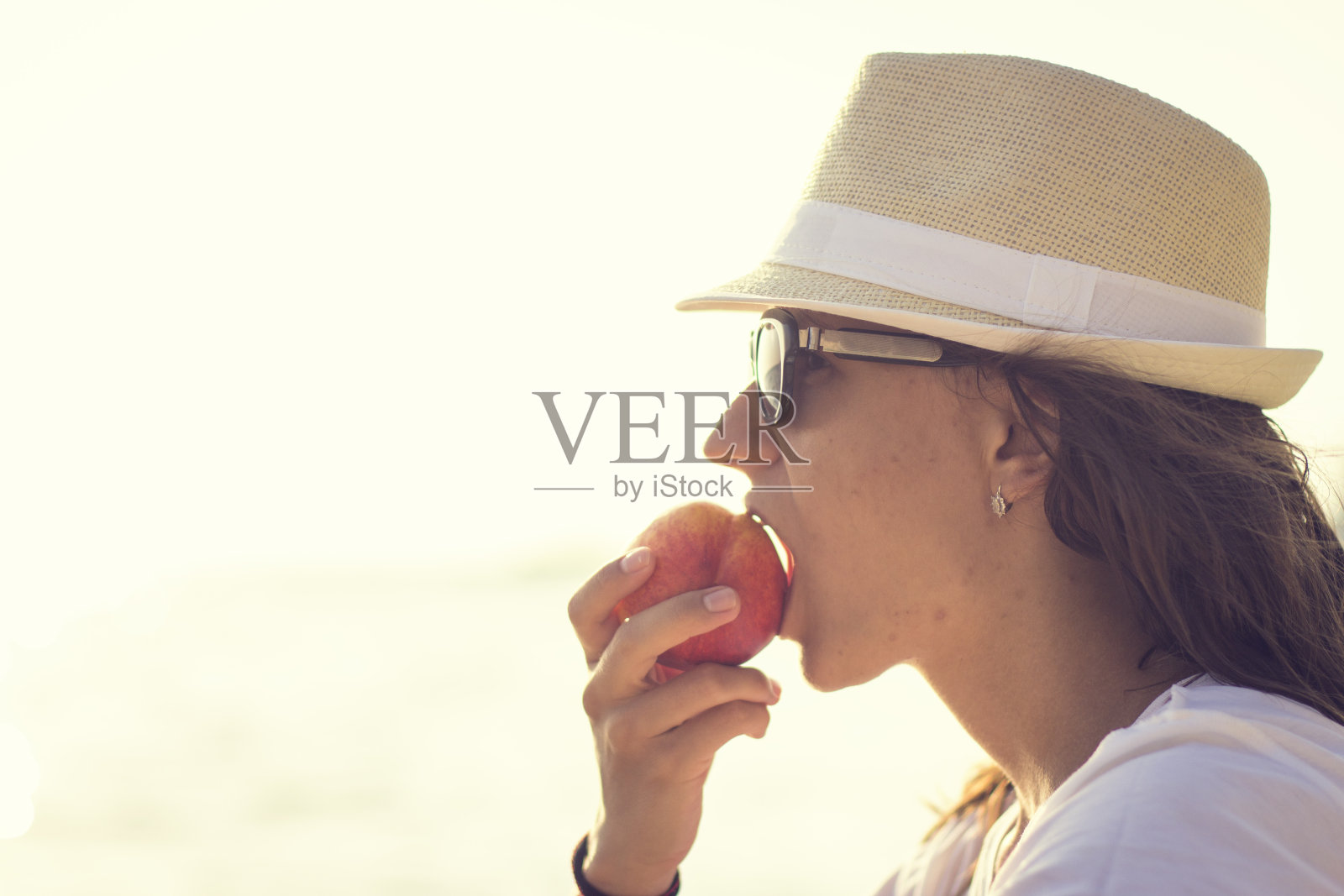 少女带着桃子靠近海边照片摄影图片