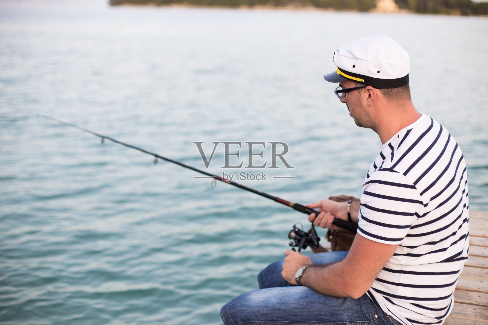 水手在码头上钓鱼照片摄影图片