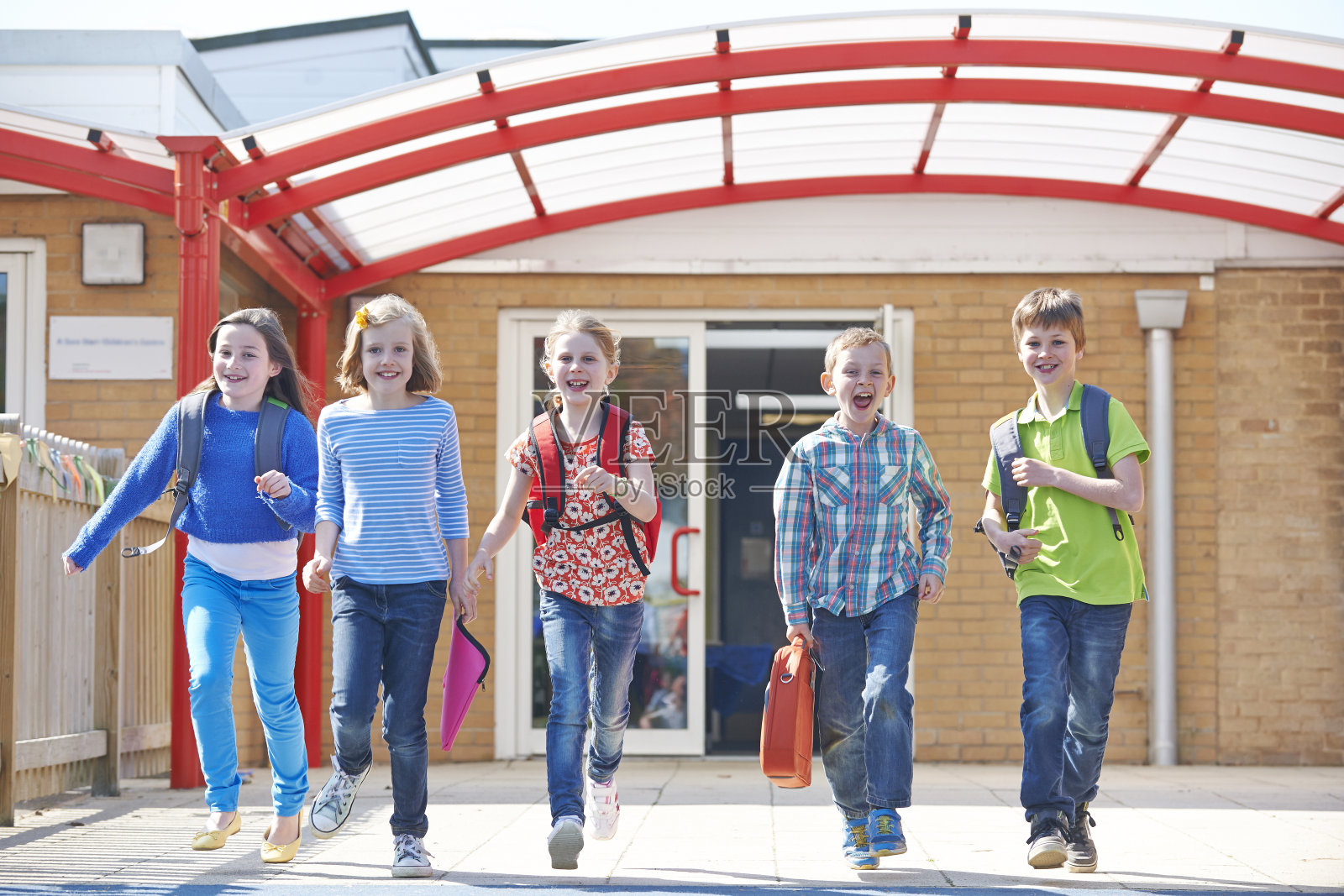 放学后，小学生跑进操场照片摄影图片