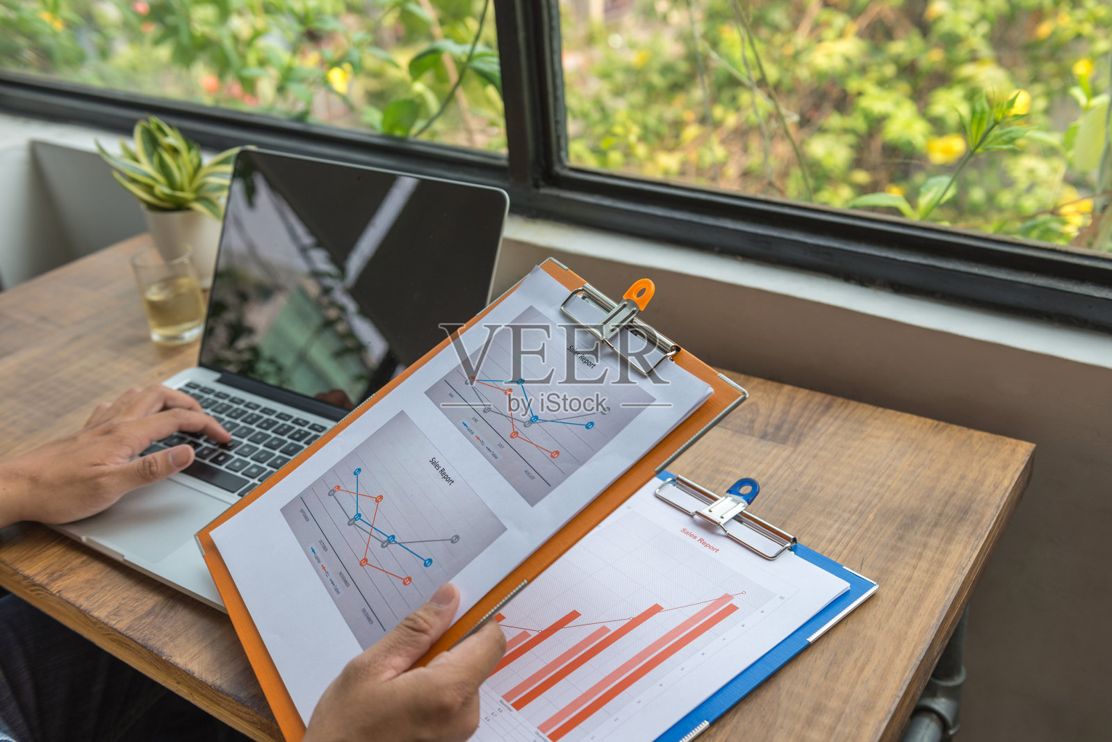 男性手打字和携带销售报告文件的特写照片摄影图片