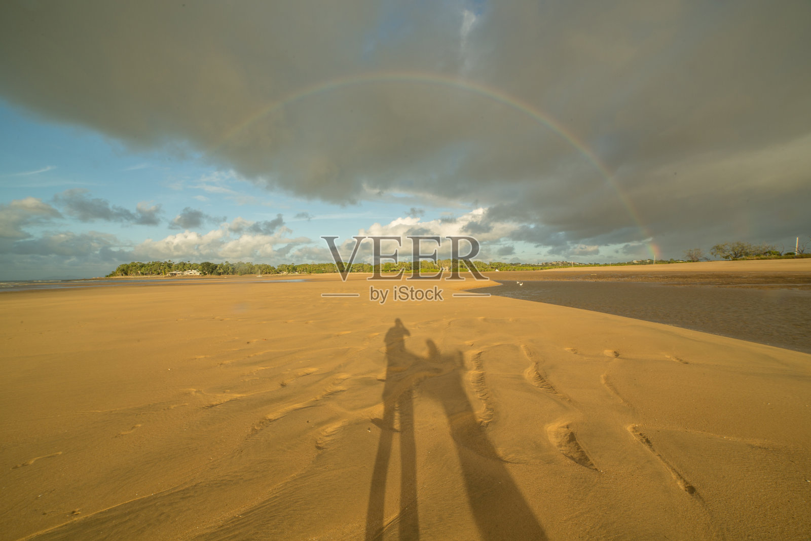 日落时沙滩上情侣的影子照片摄影图片