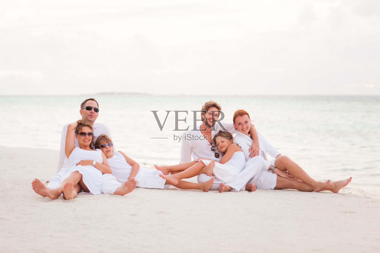 两个家庭坐在海滩上照片摄影图片