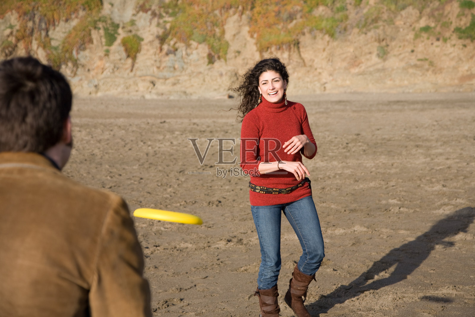 在海滩玩飞盘照片摄影图片